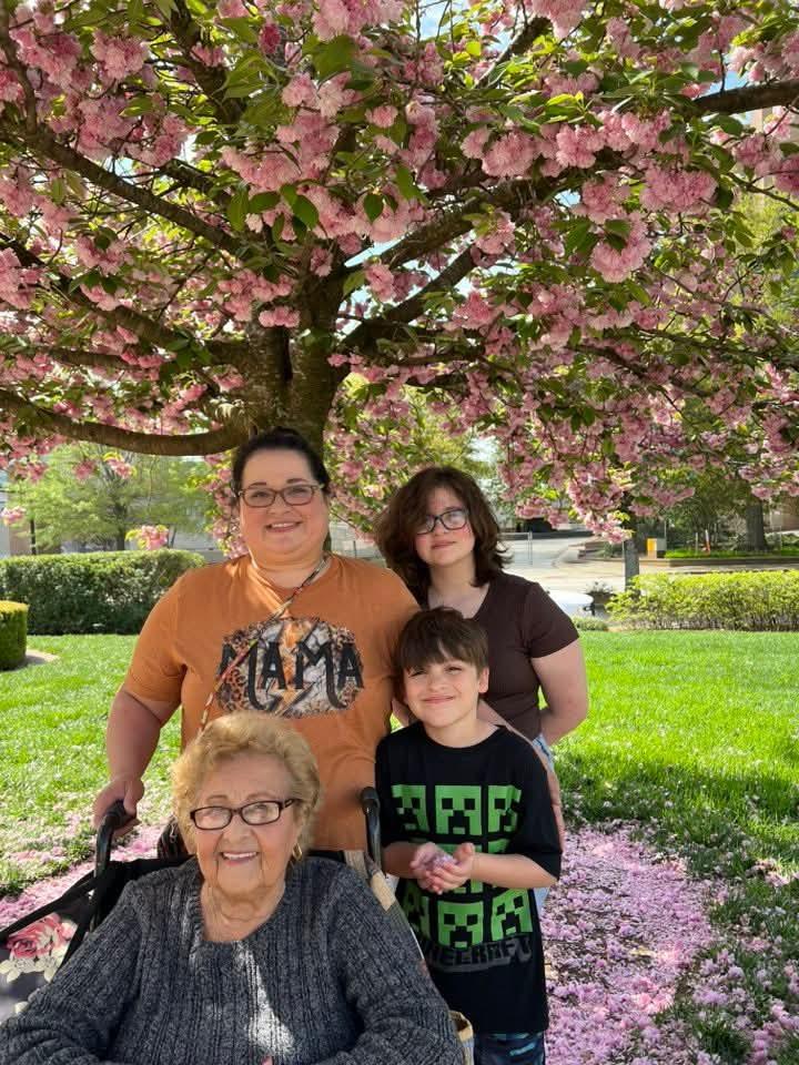A group of people posing for a photo under a tree