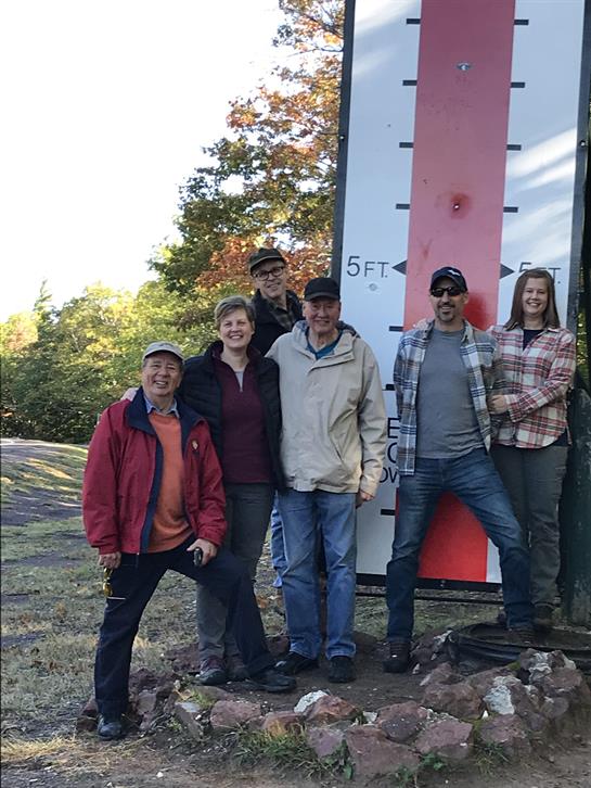 A group of people standing in front of a sign