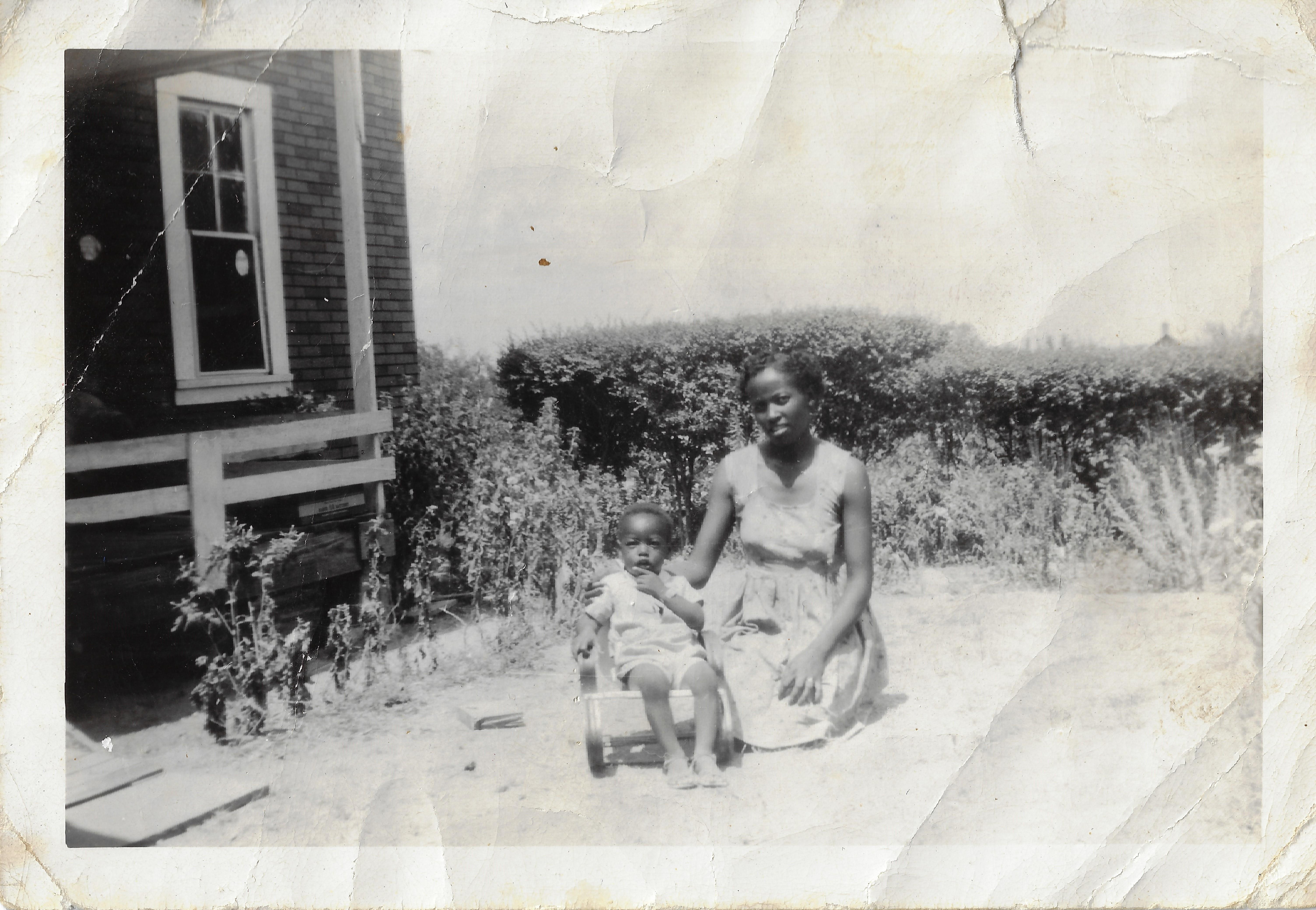A woman sitting on a stroller with a baby