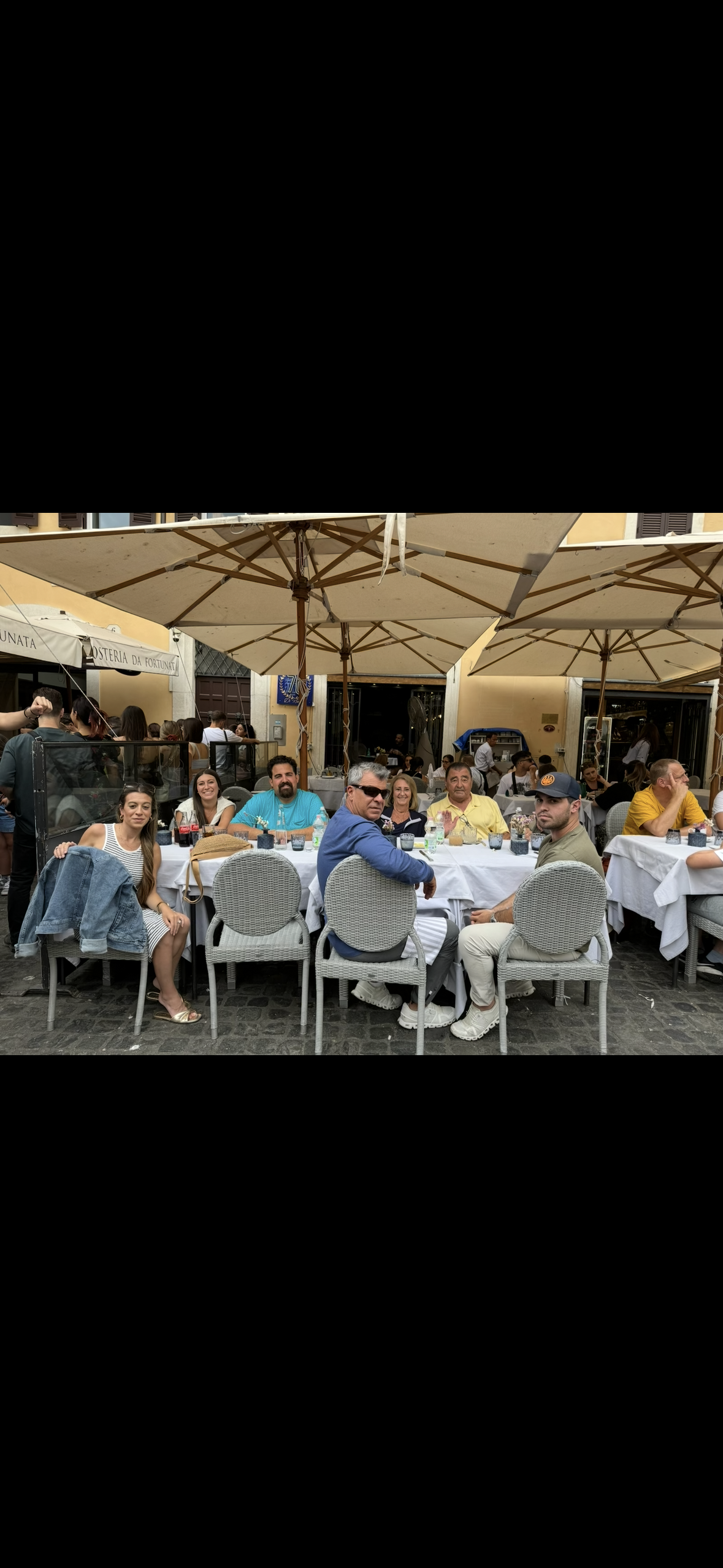 A group of people sitting at tables outside