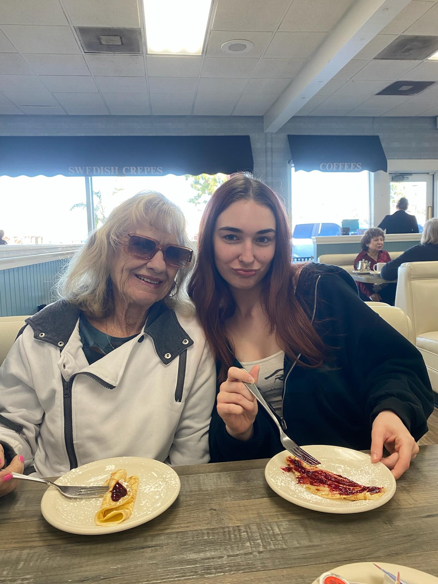 Two women sitting at a table with plates of food