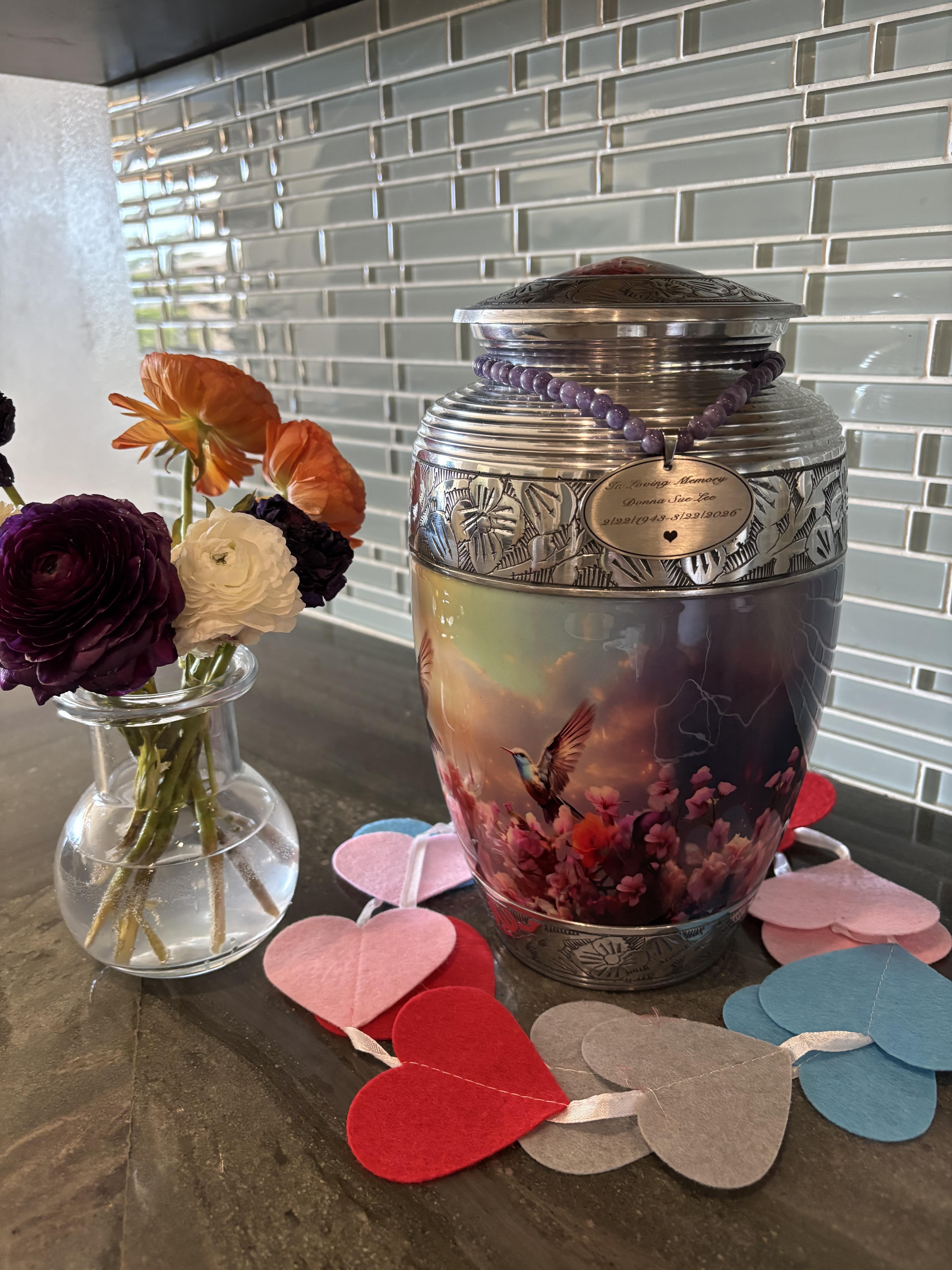 A urn with flowers and hearts on a table