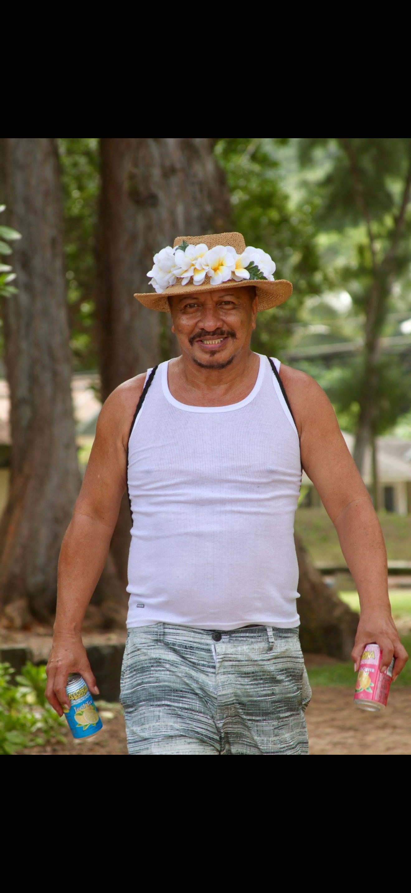 A man wearing a hat and flowers on his head