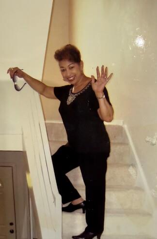 A woman standing on stairs holding a hand up