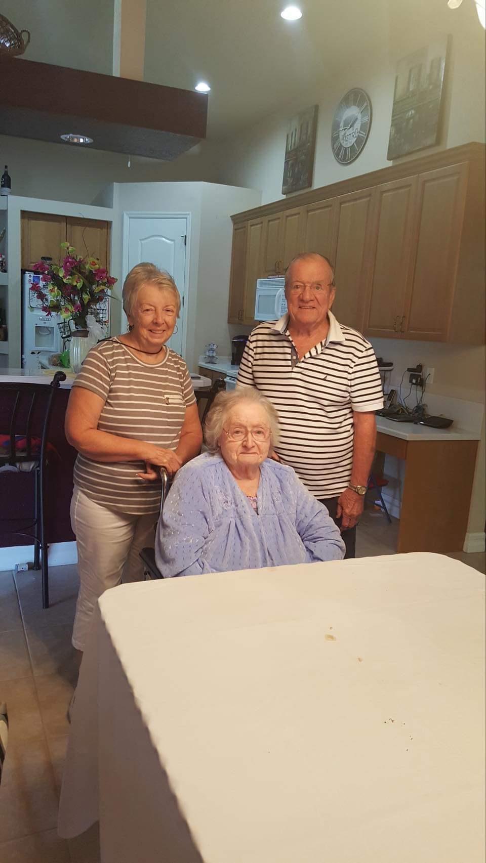 A group of people standing around a woman in a wheelchair