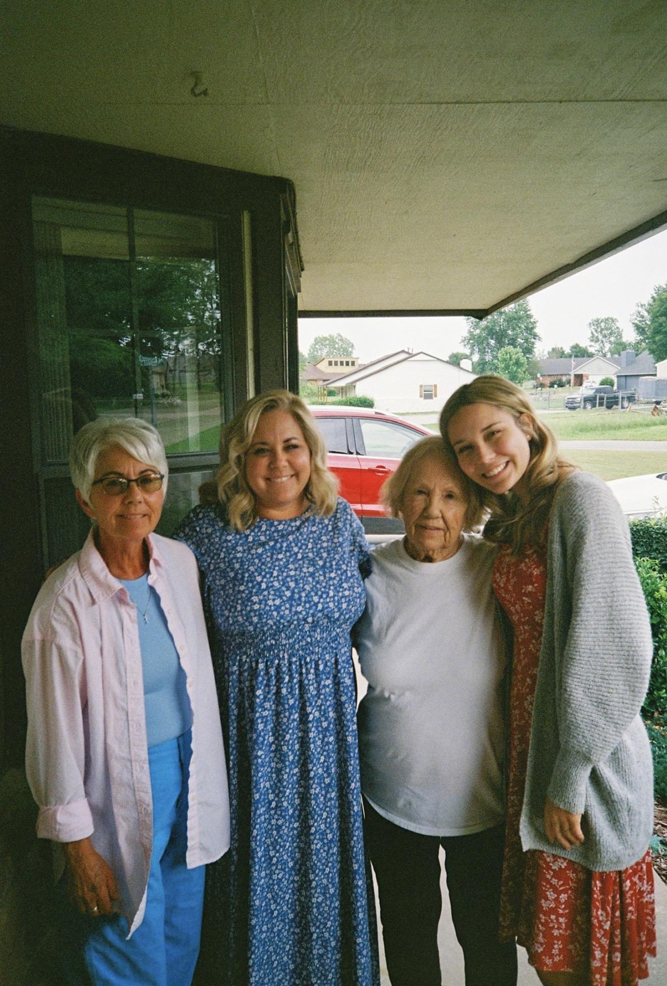 A group of women standing together outside a house