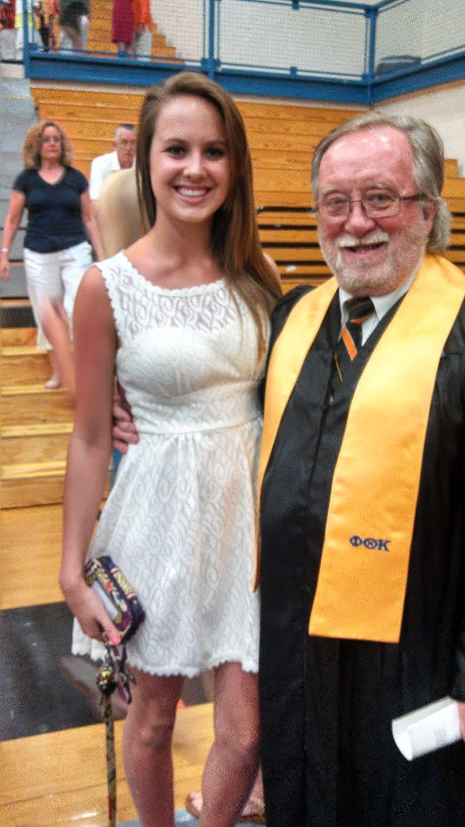 A woman in a white dress and a man in a graduation gown