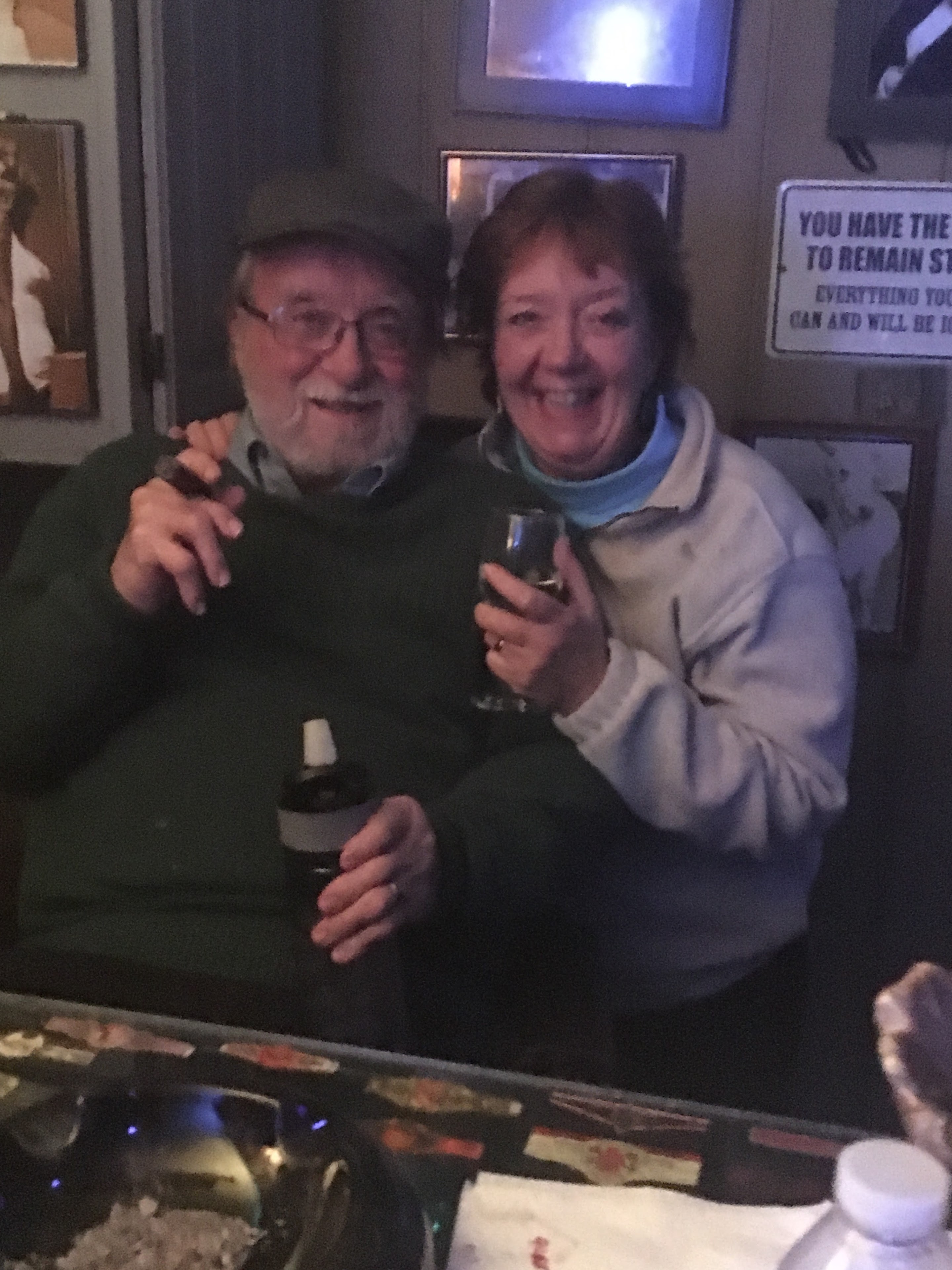 A man and woman sitting at a table with a bottle of wine
