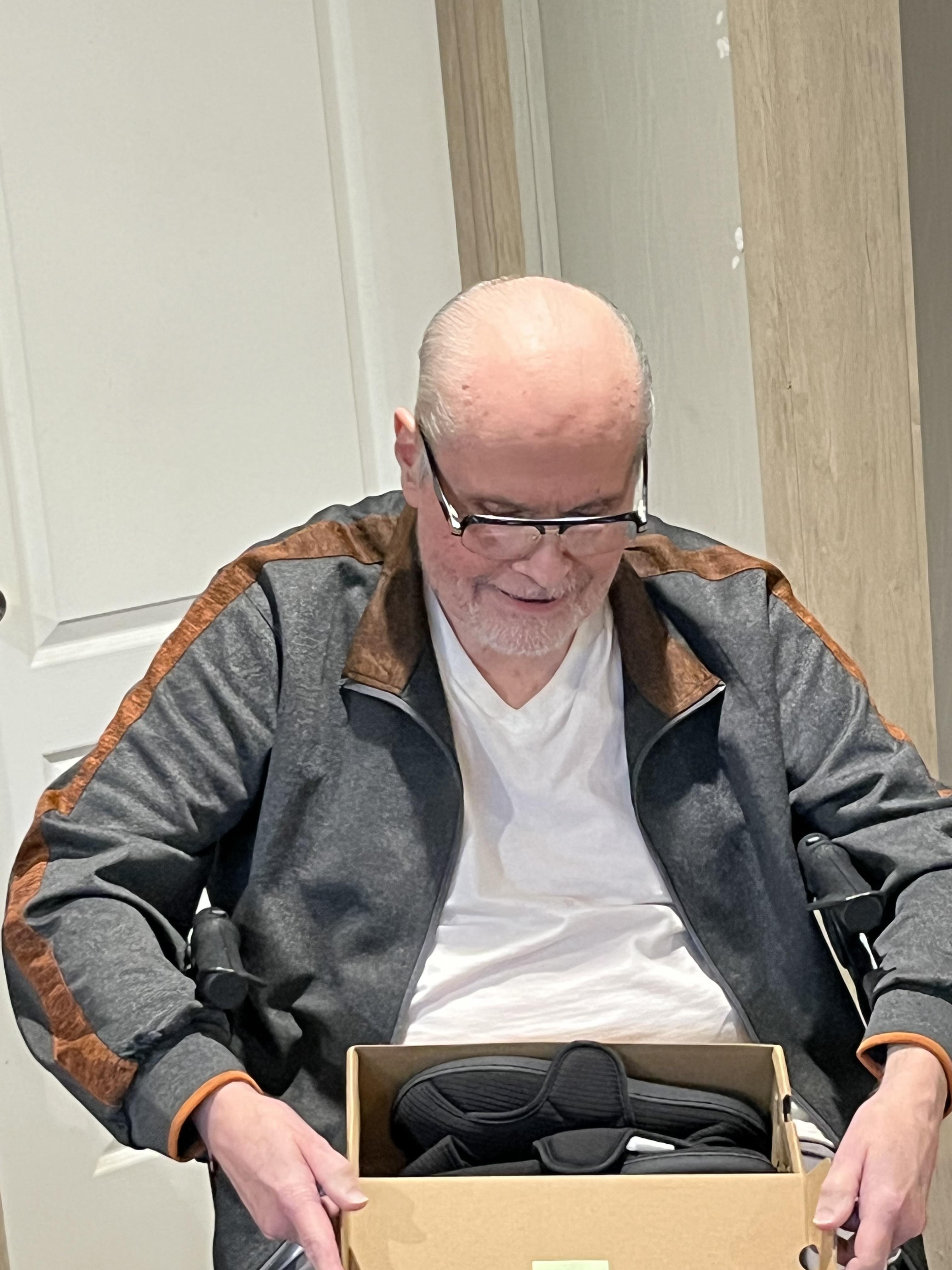 A man sitting in a chair holding a shoe box