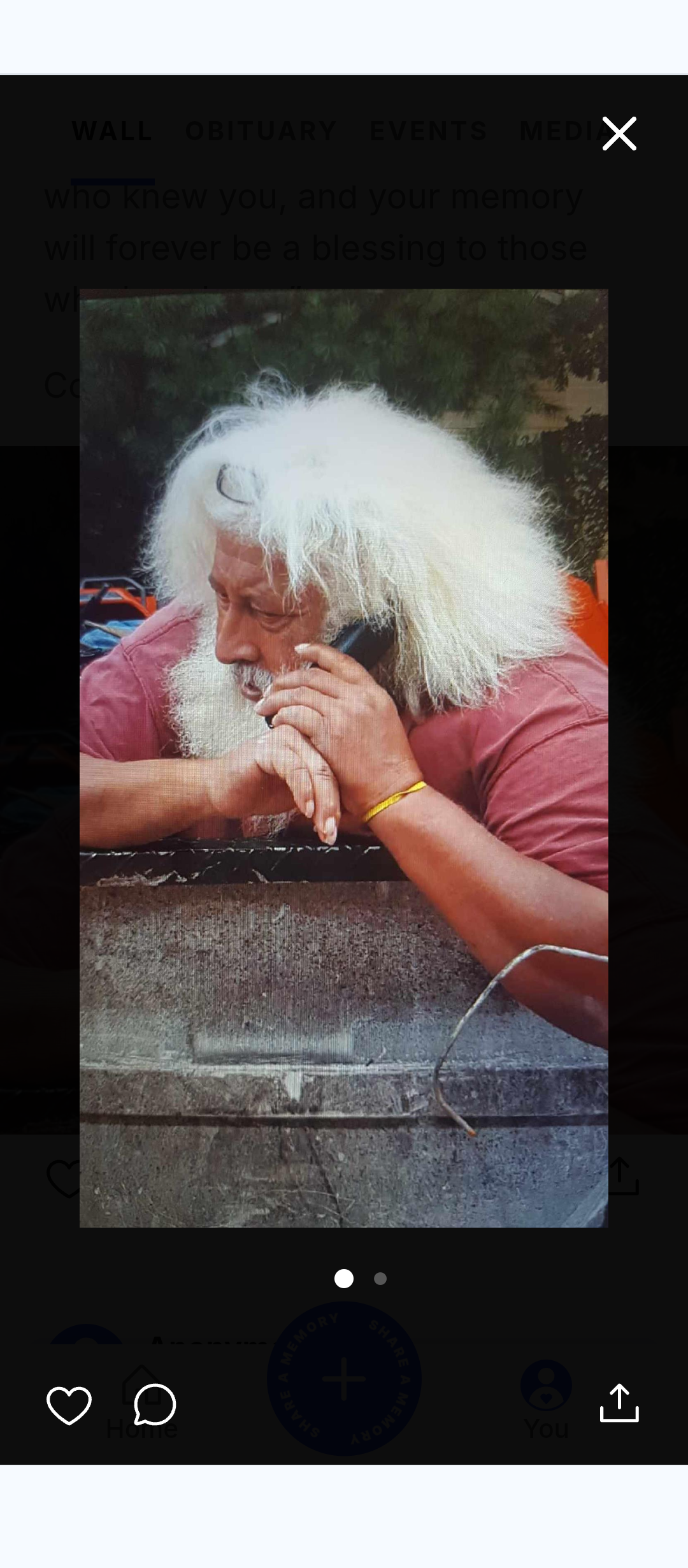 A man with white hair talking on a cell phone