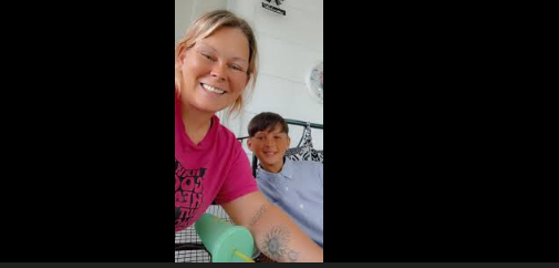 A woman and boy sitting on a bed