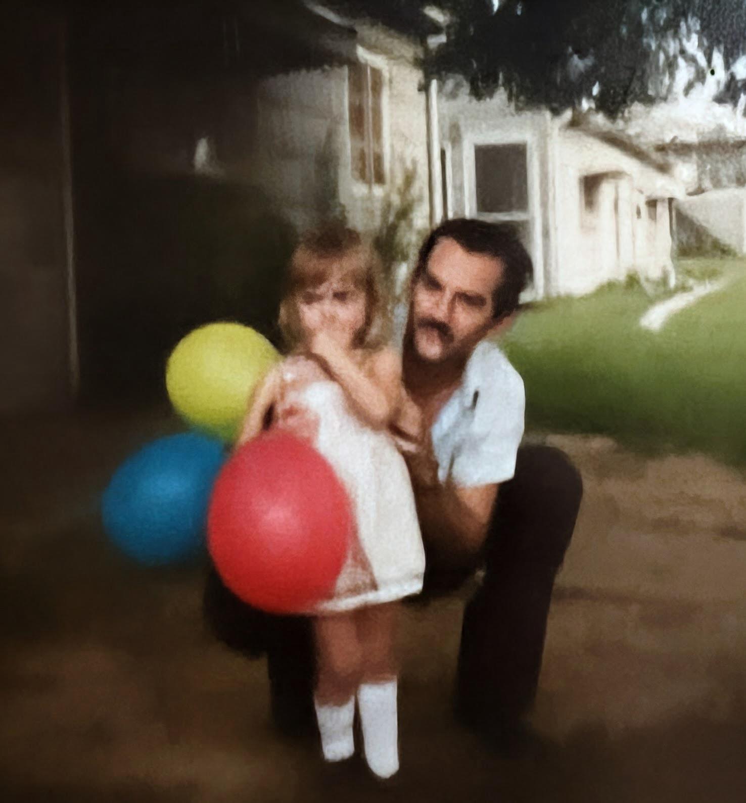 A man holding a child with balloons