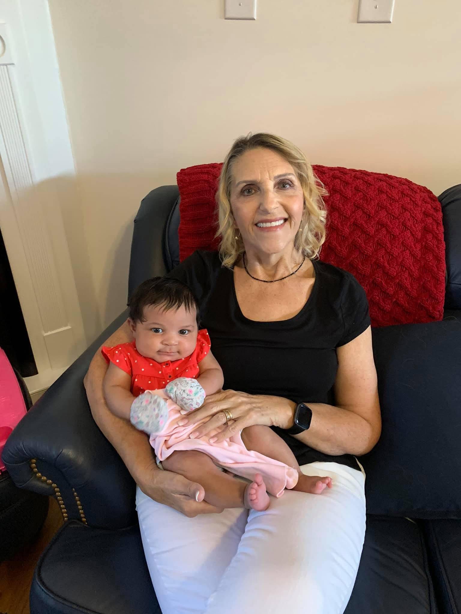 A woman sitting on a couch holding a baby