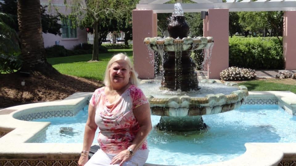 A woman sitting in front of a fountain