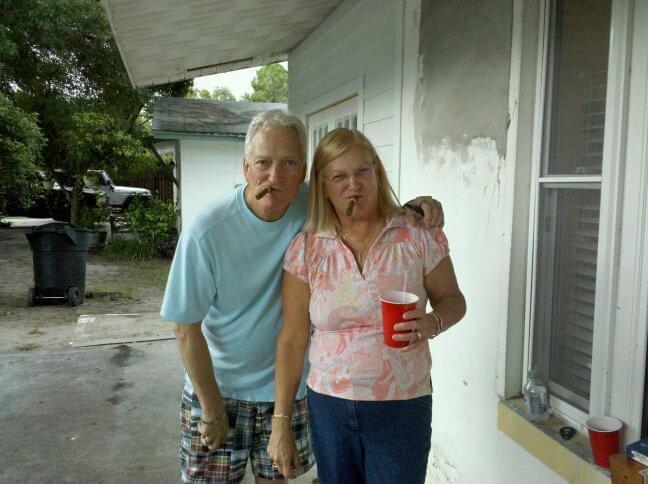 A man and woman standing outside a house