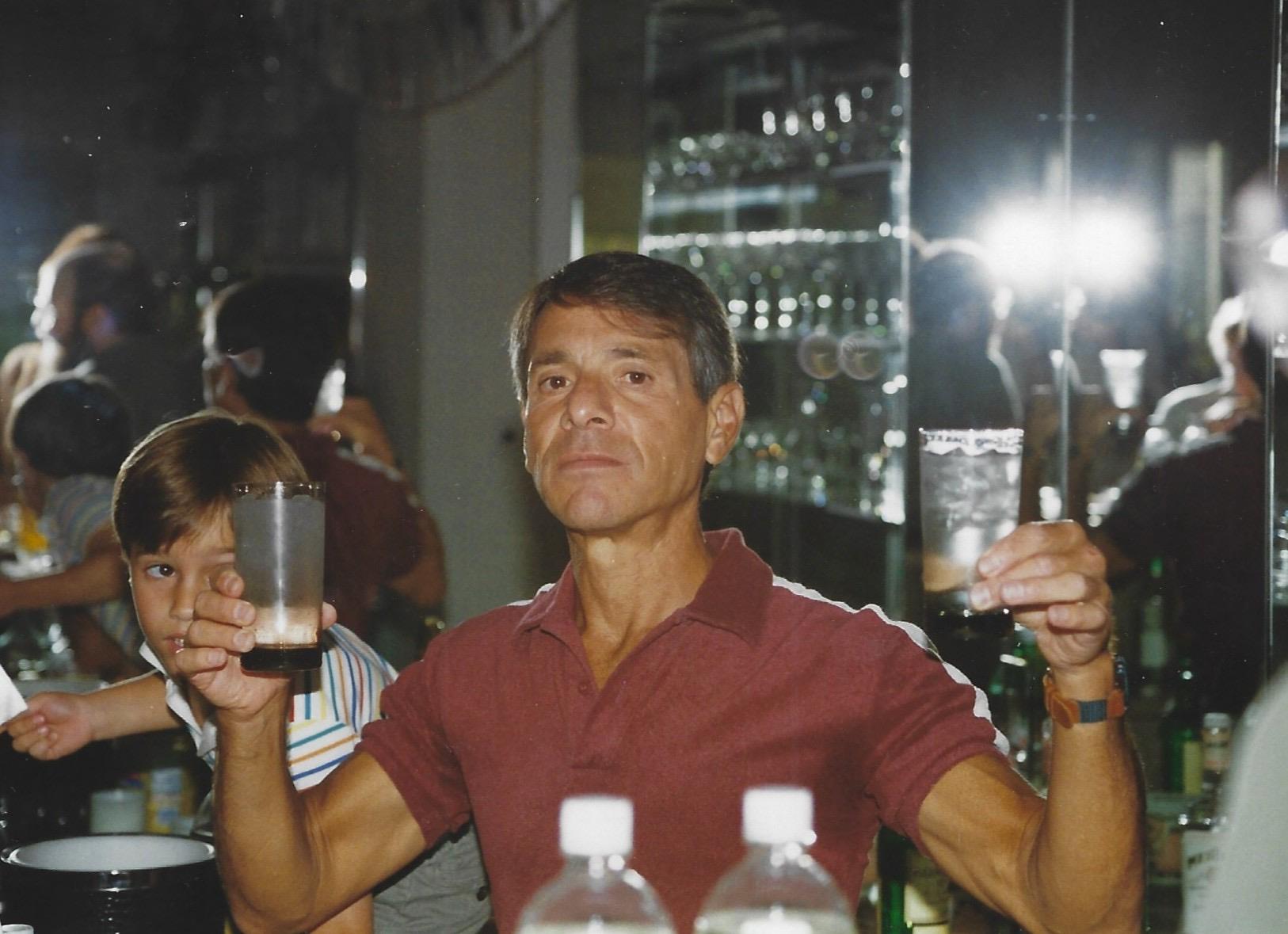 A man holding up a glass of liquid