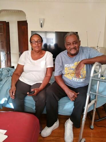 A man and woman sitting on a bed
