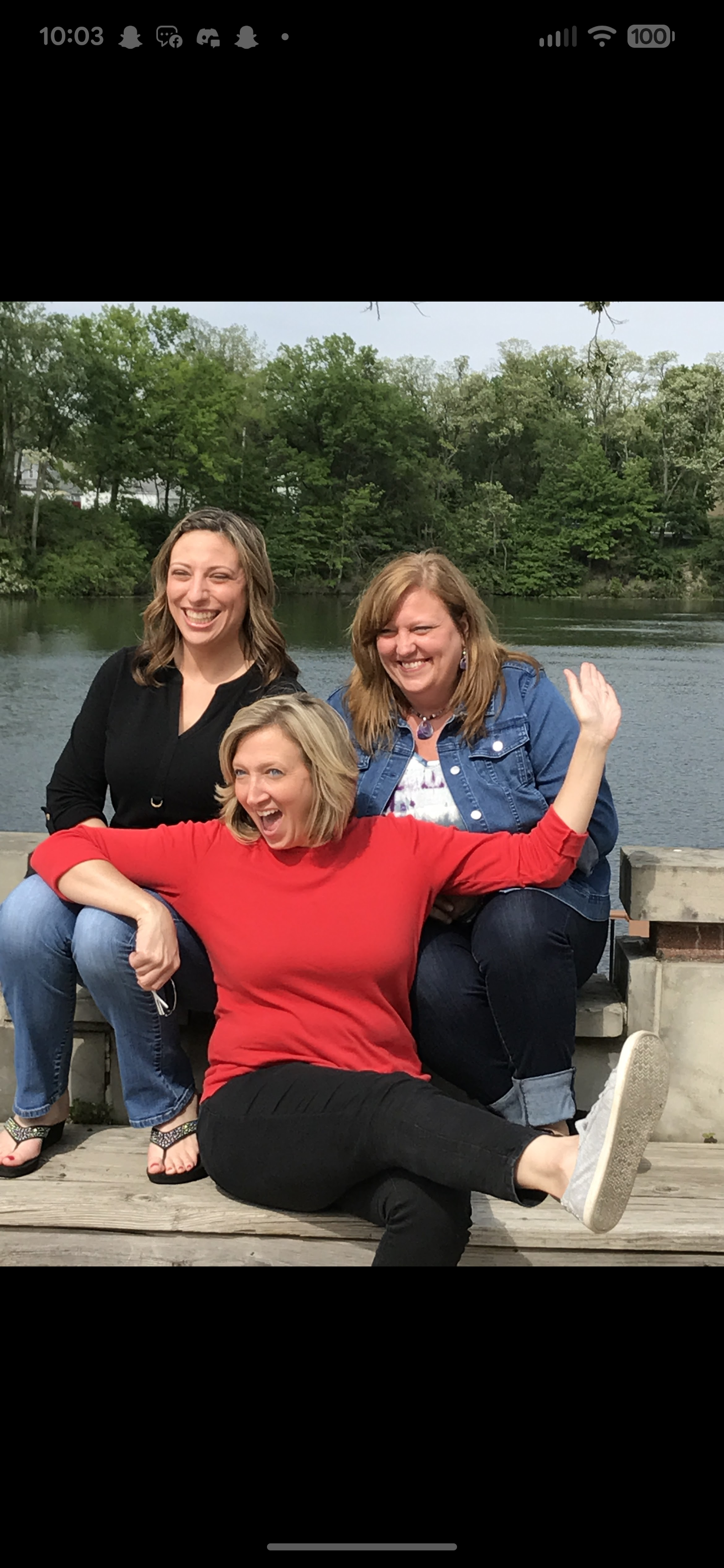 A group of women sitting on a ledge by a body of water