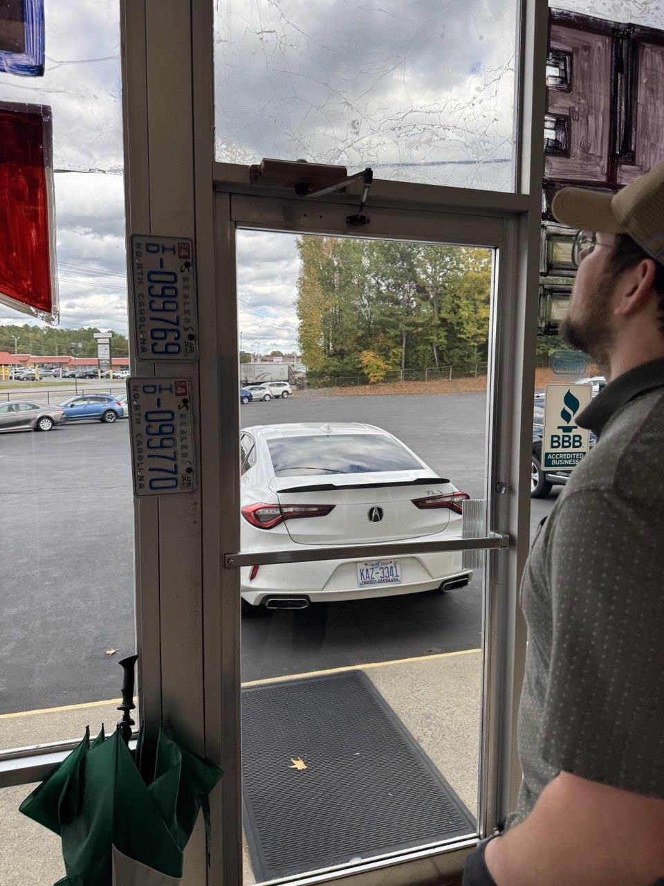 A man looking at a car in a parking lot
