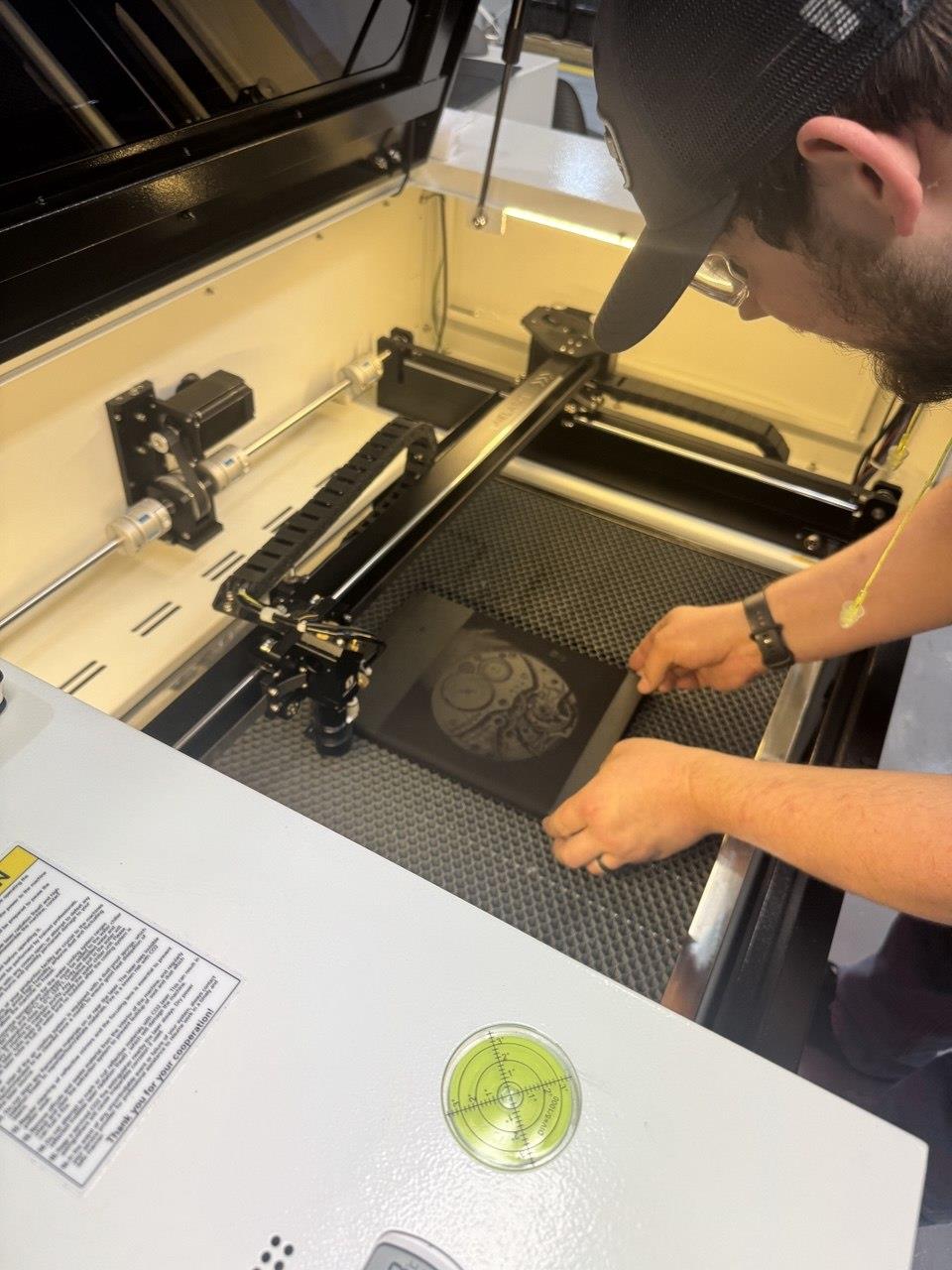 A man using a machine to cut a picture