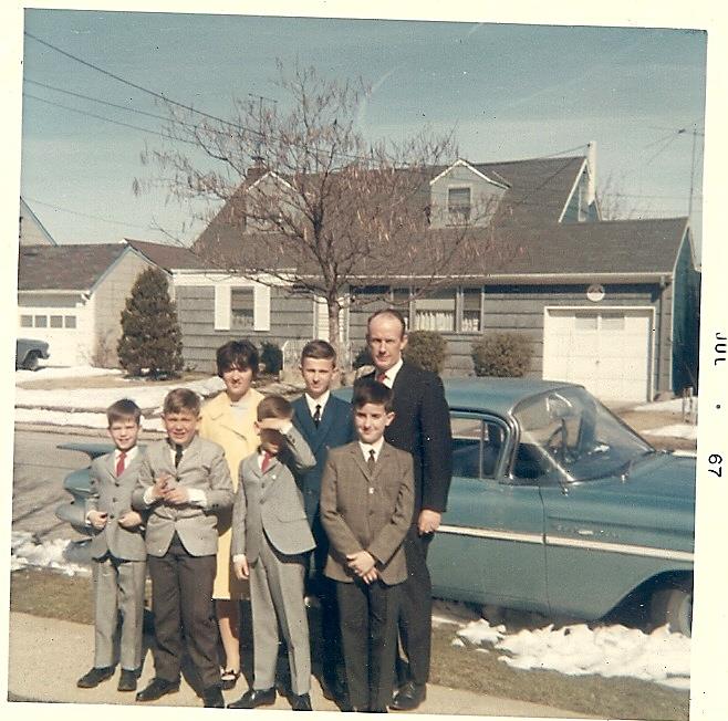 A group of people standing in front of a car