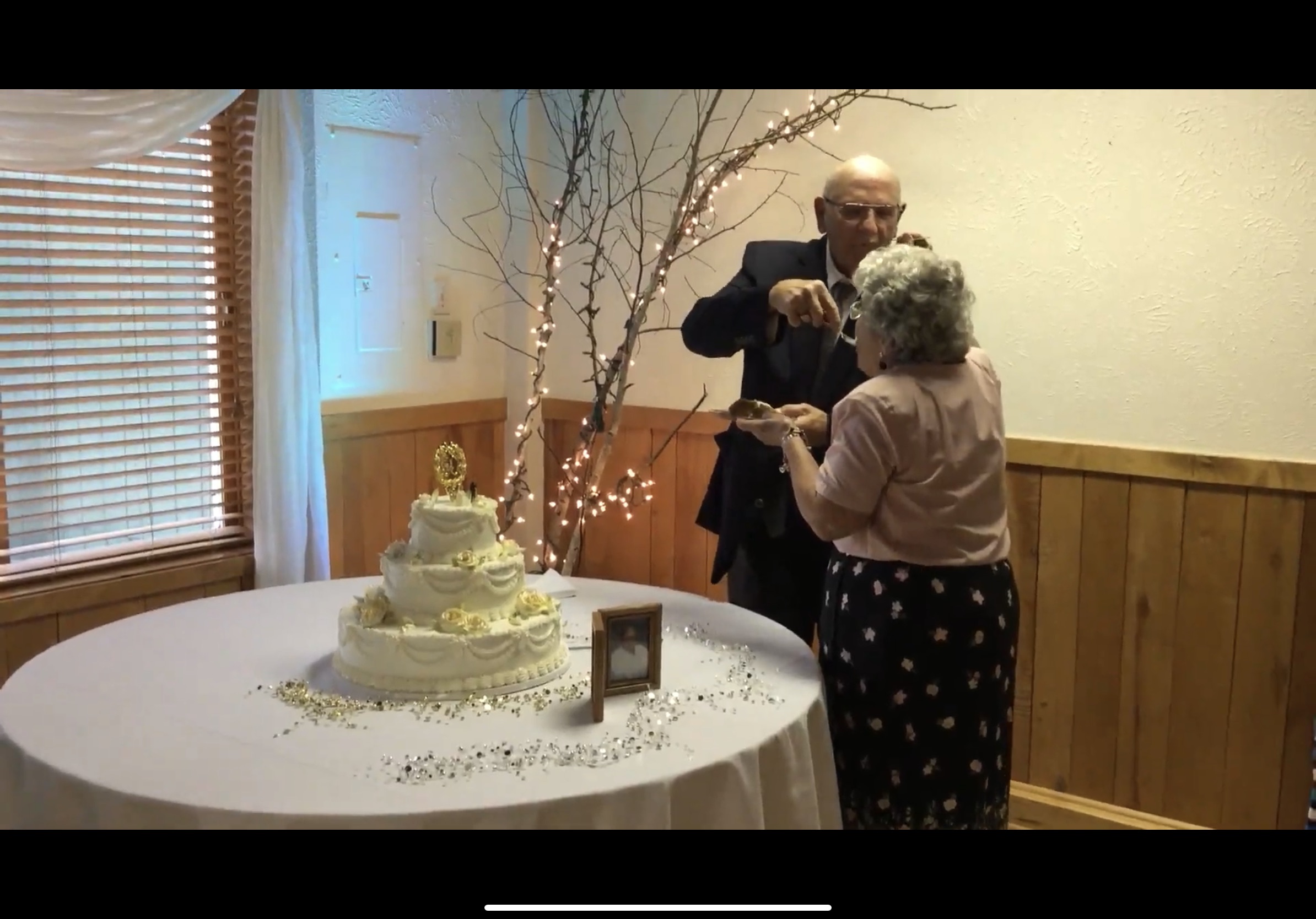 A man and woman standing around a cake