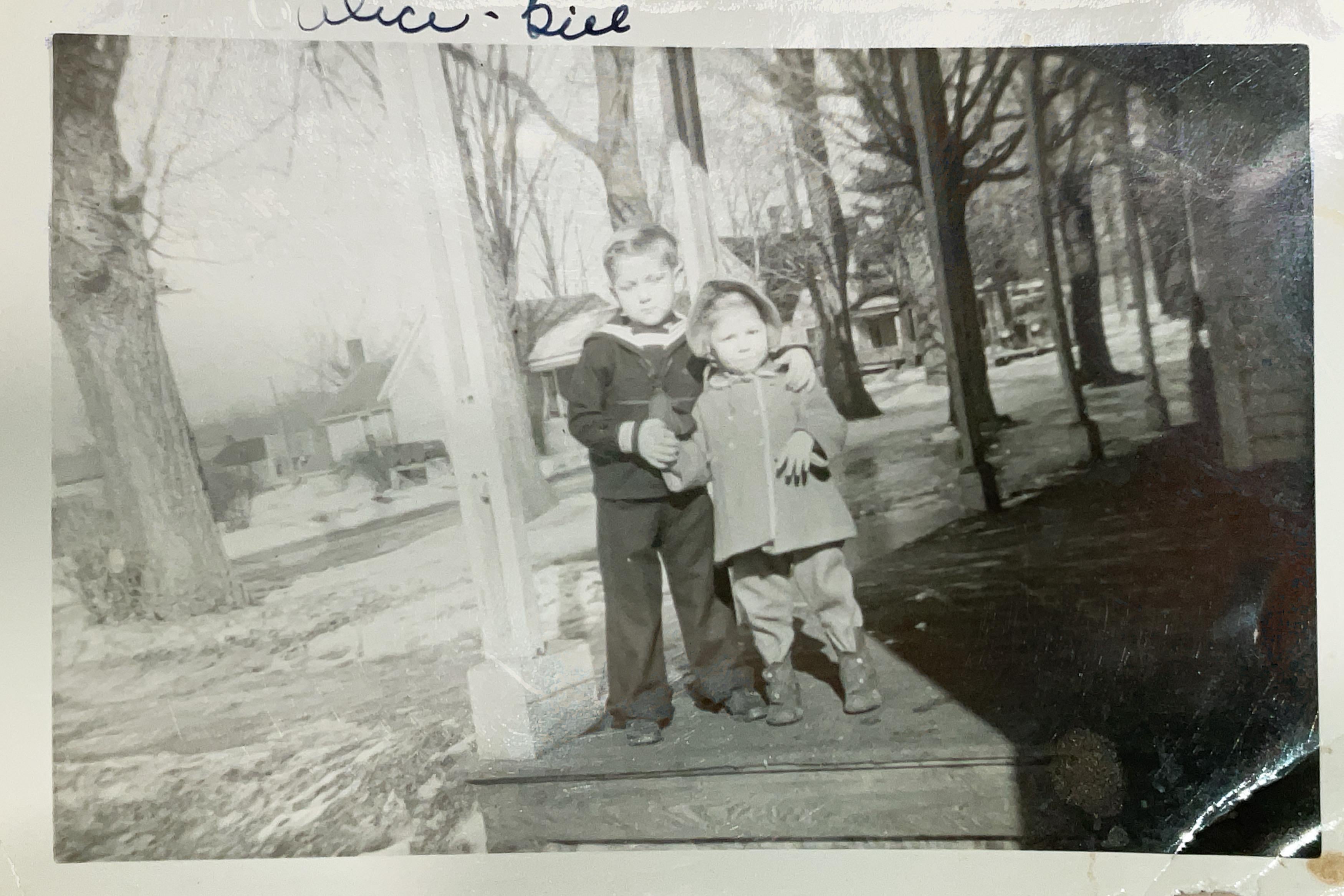 A couple of children standing on a porch