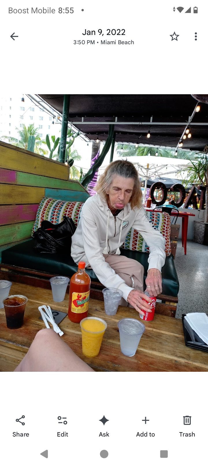 A man sitting on a bench with drinks and a drink in it