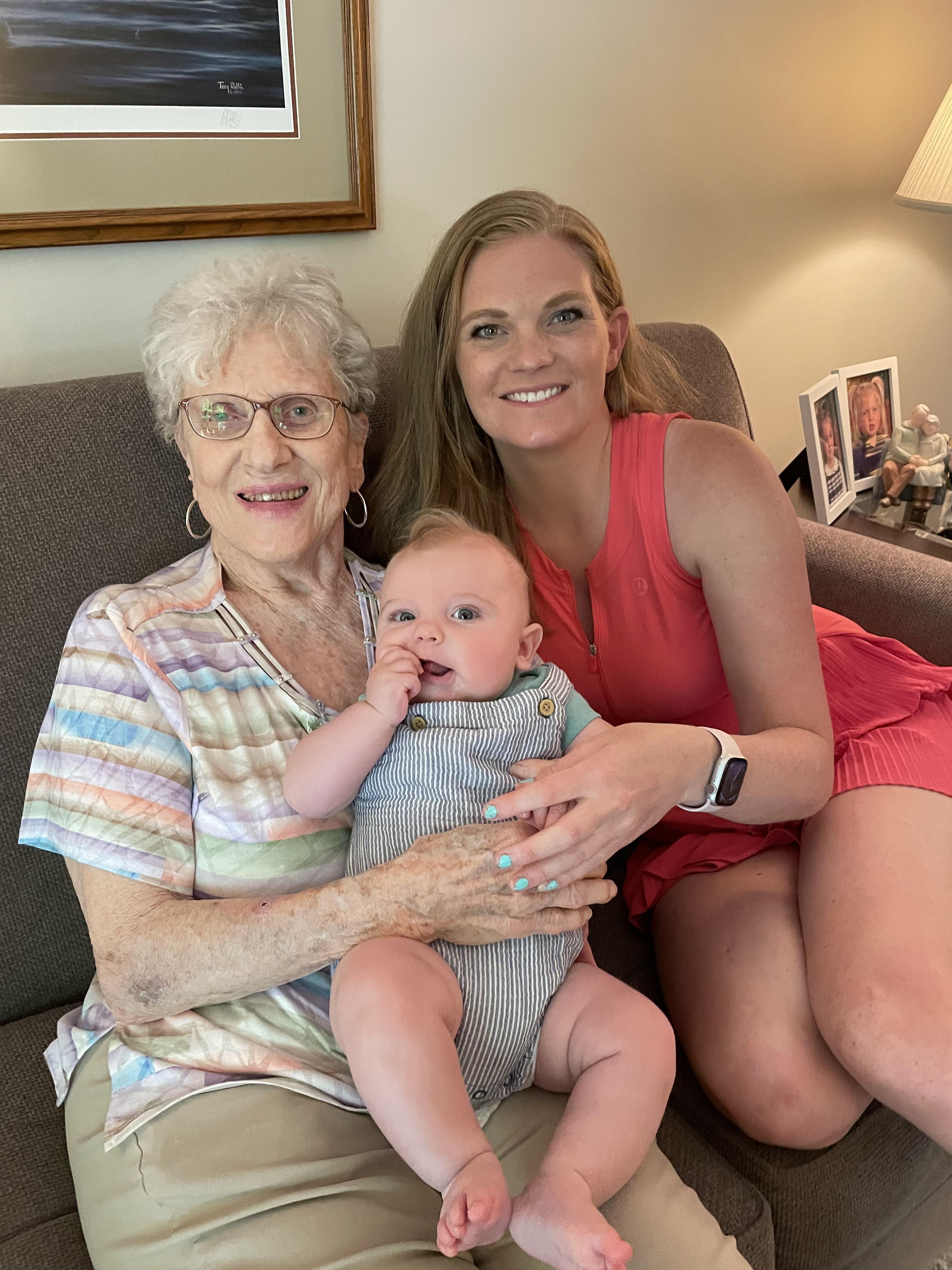 A woman holding a baby and smiling