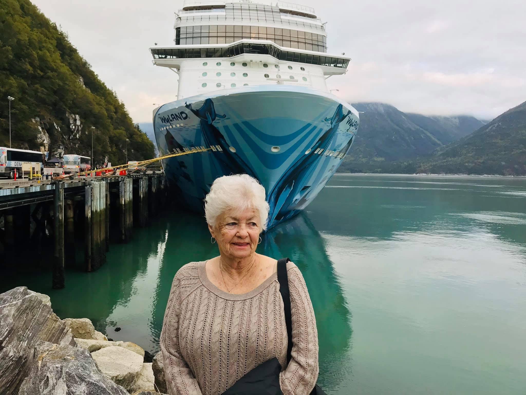 A woman standing in front of a large ship
