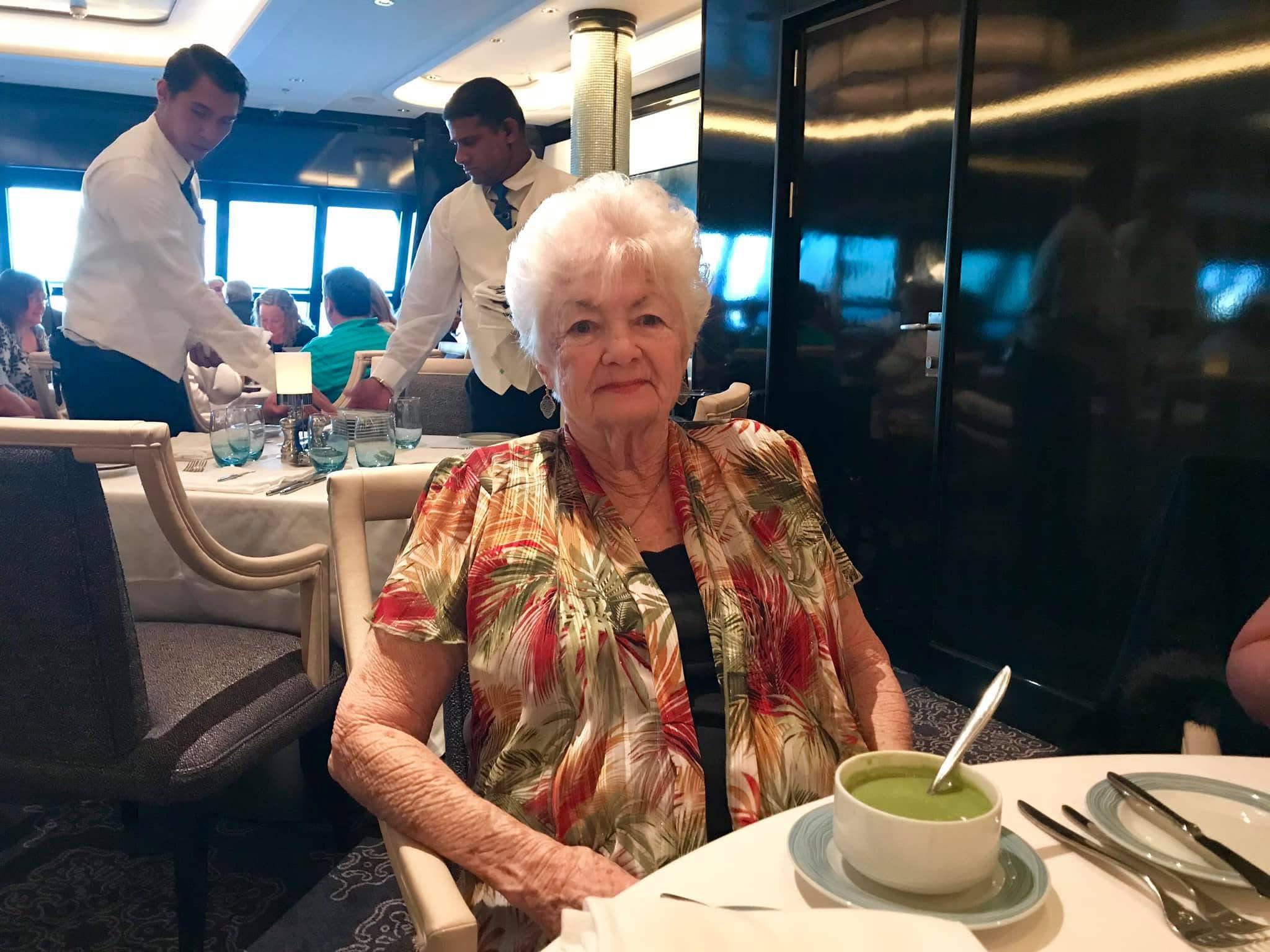 A woman sitting at a table with a bowl of soup