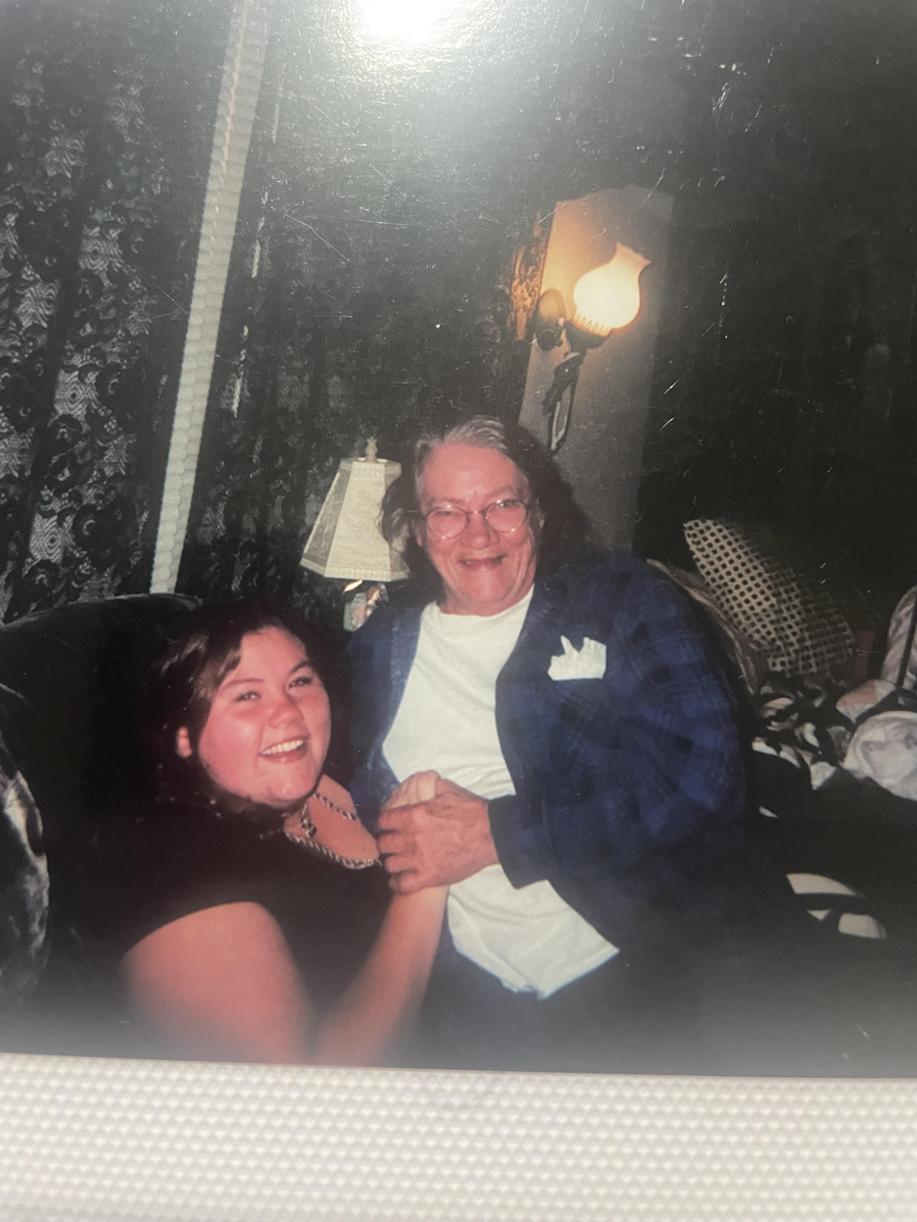 A man and woman sitting on a couch holding hands