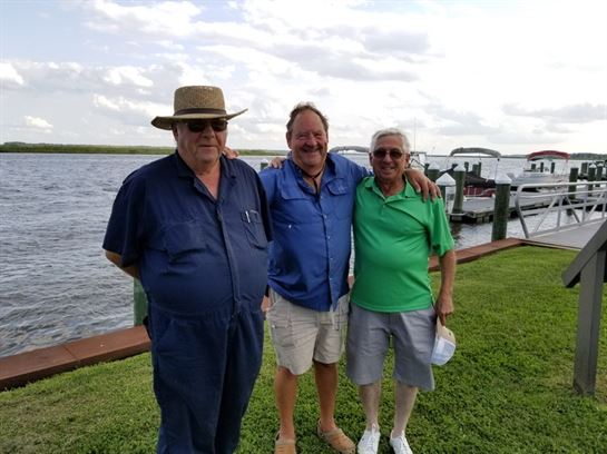 A group of people standing on grass by water