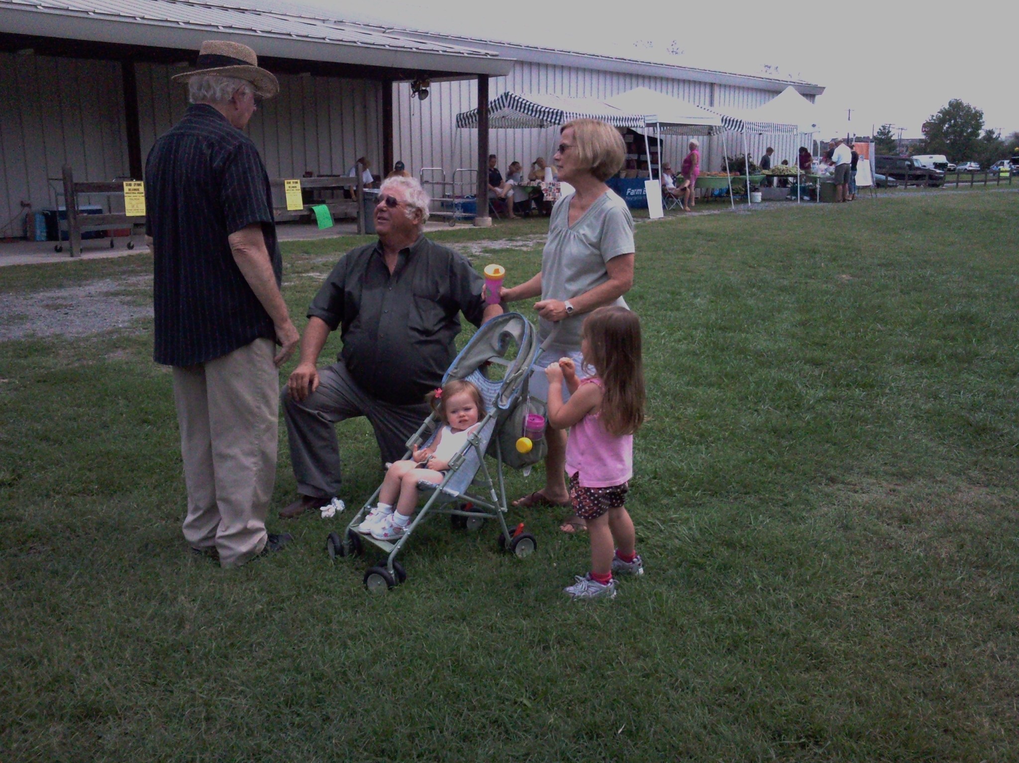 A group of people standing in a grassy area