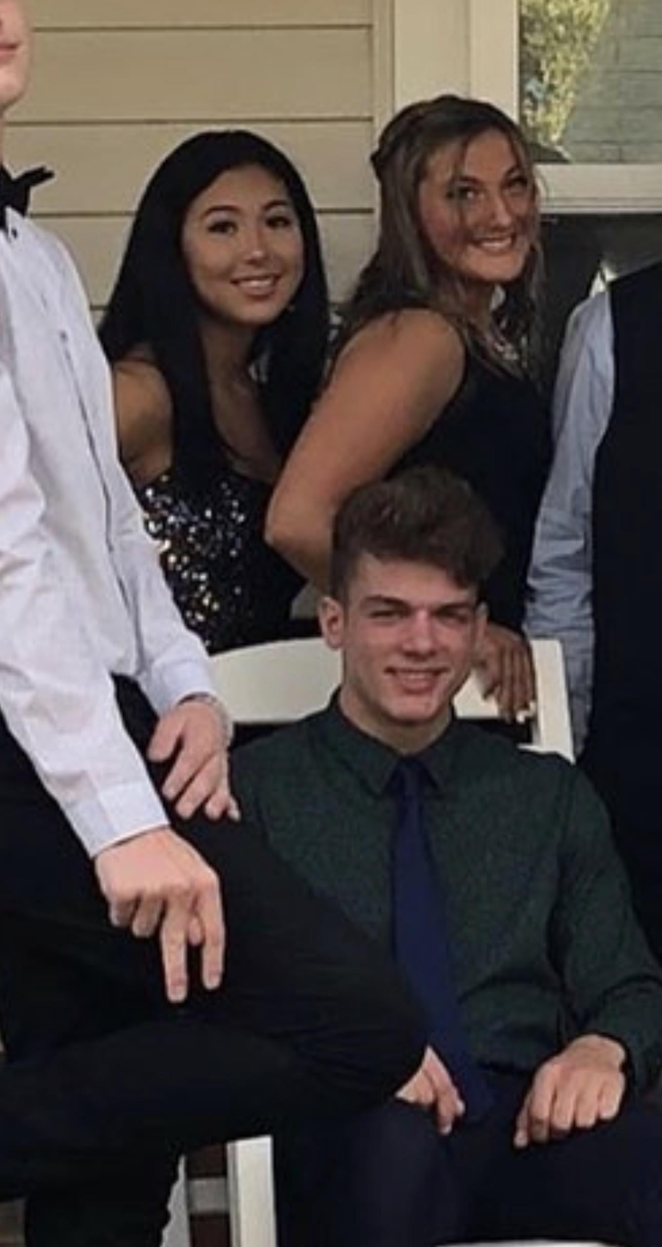 A man sitting in a chair with other people around him