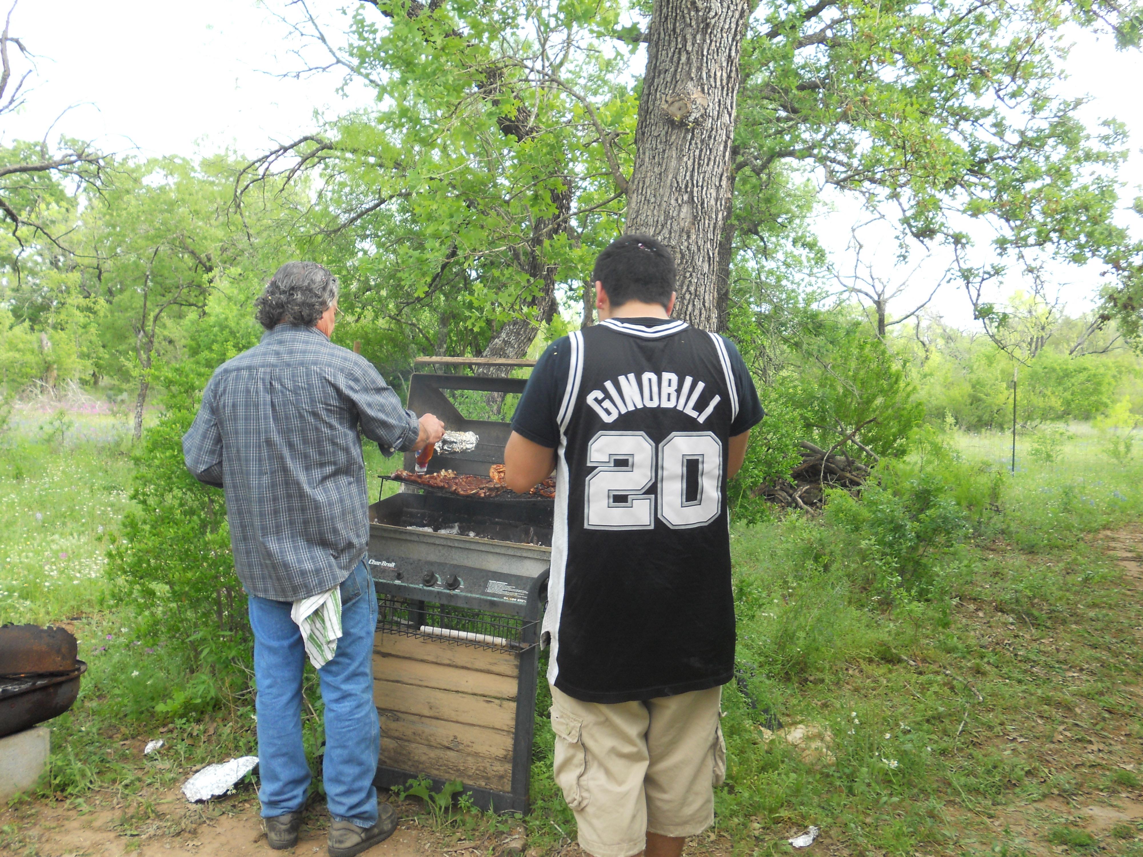 A couple of men grilling food