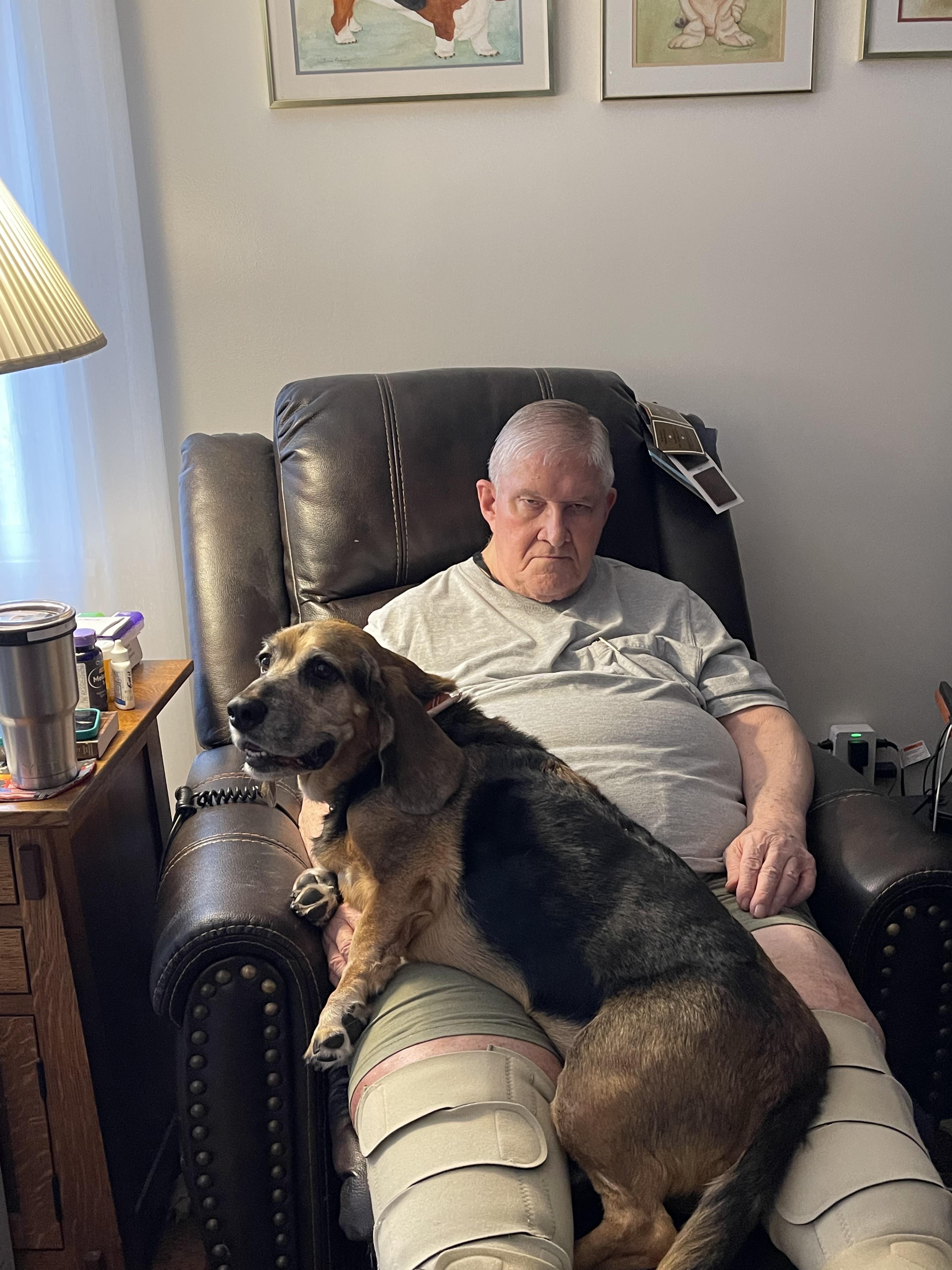 A man sitting in a chair with a dog