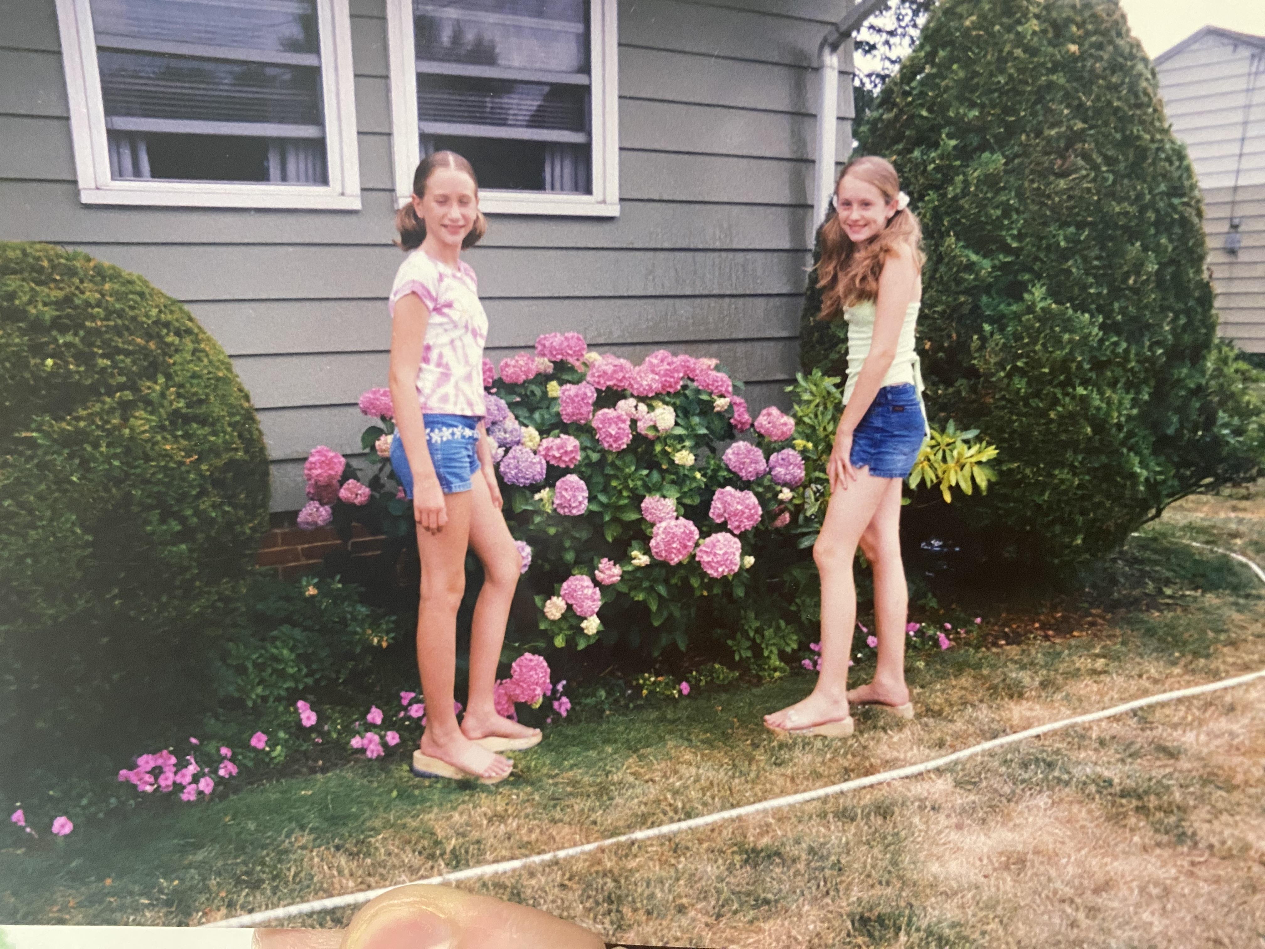Two girls standing in front of a house