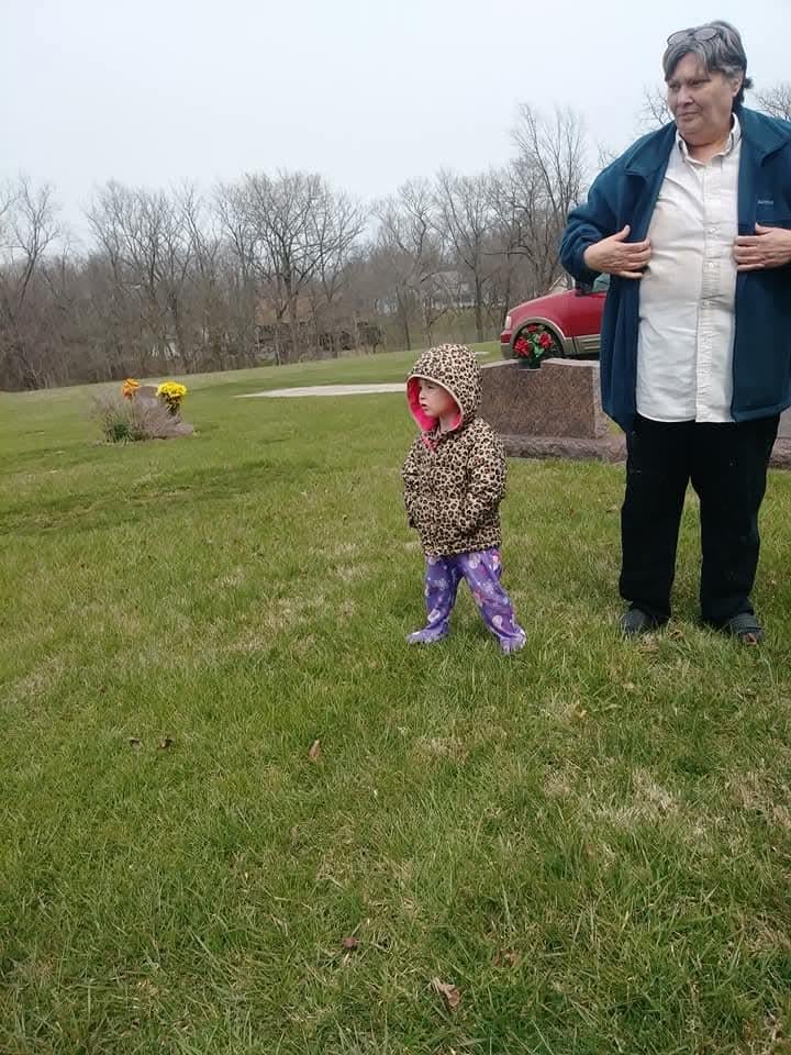 A man and child standing in a grassy field