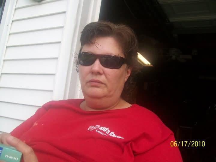 A woman wearing sunglasses and a red shirt