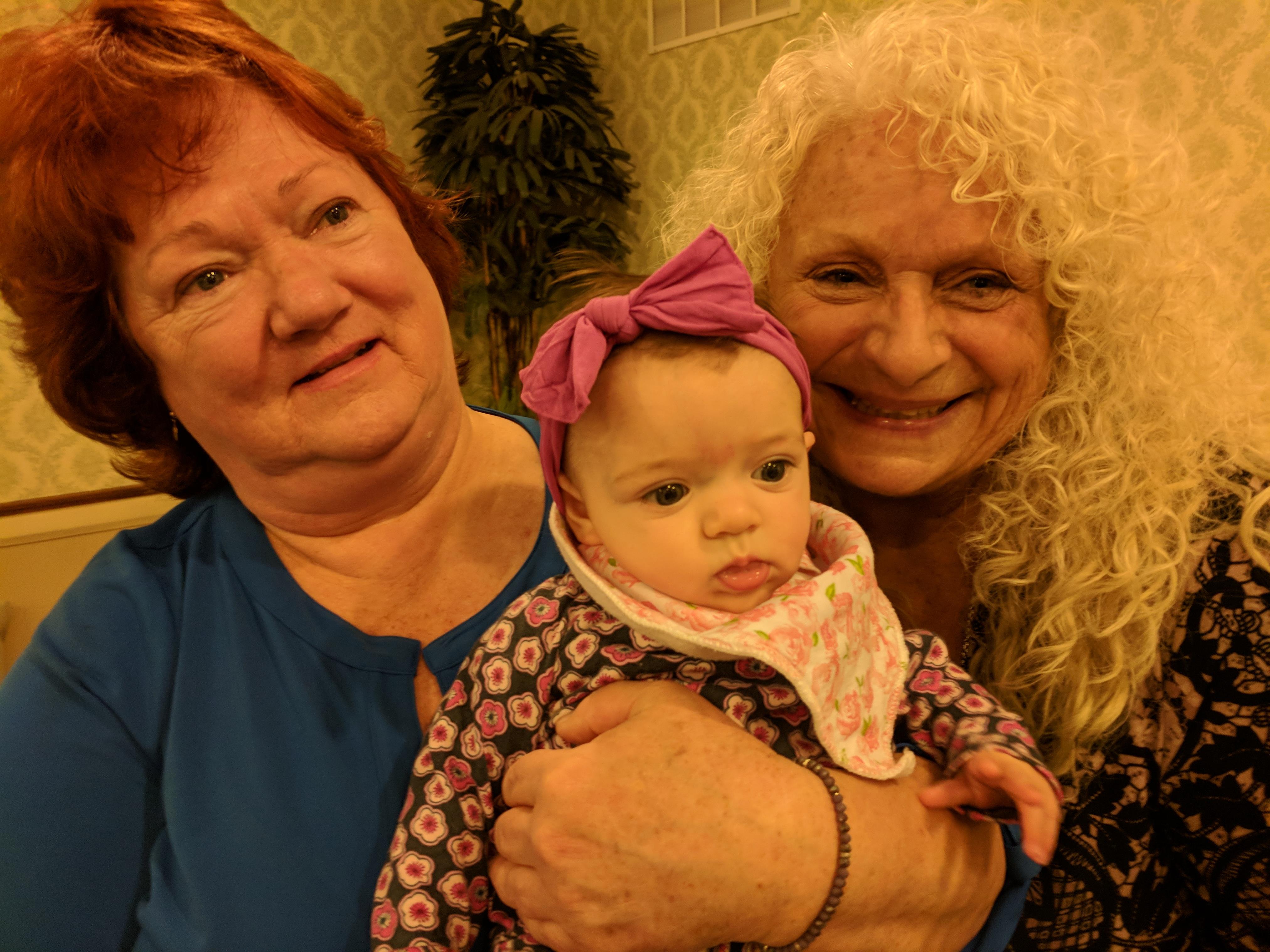 Two women holding a baby