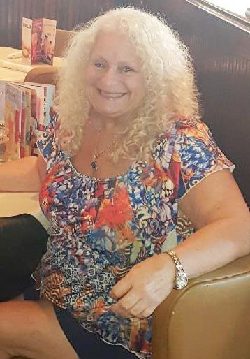 A woman with curly blonde hair smiling