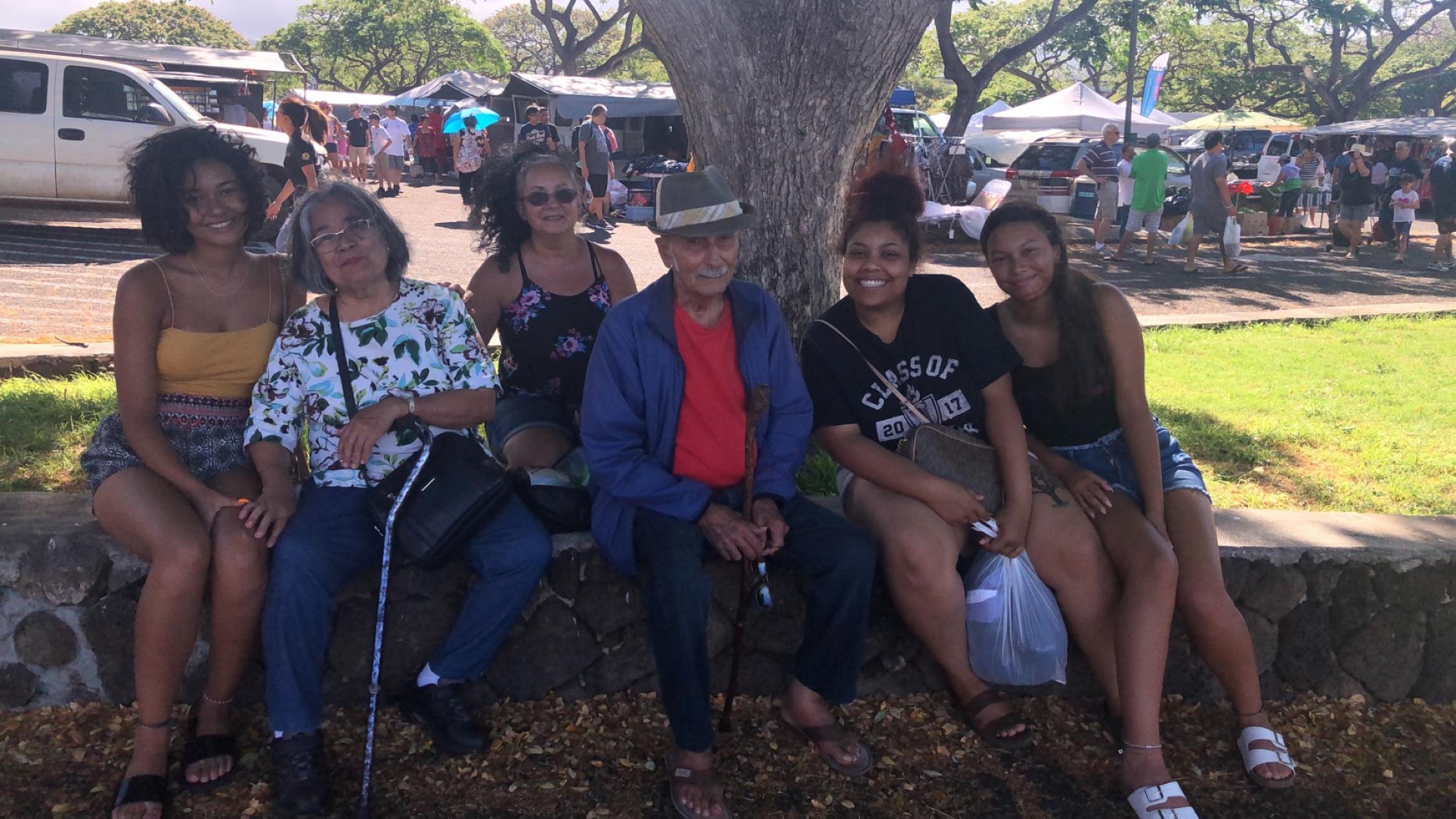 A group of people sitting under a tree