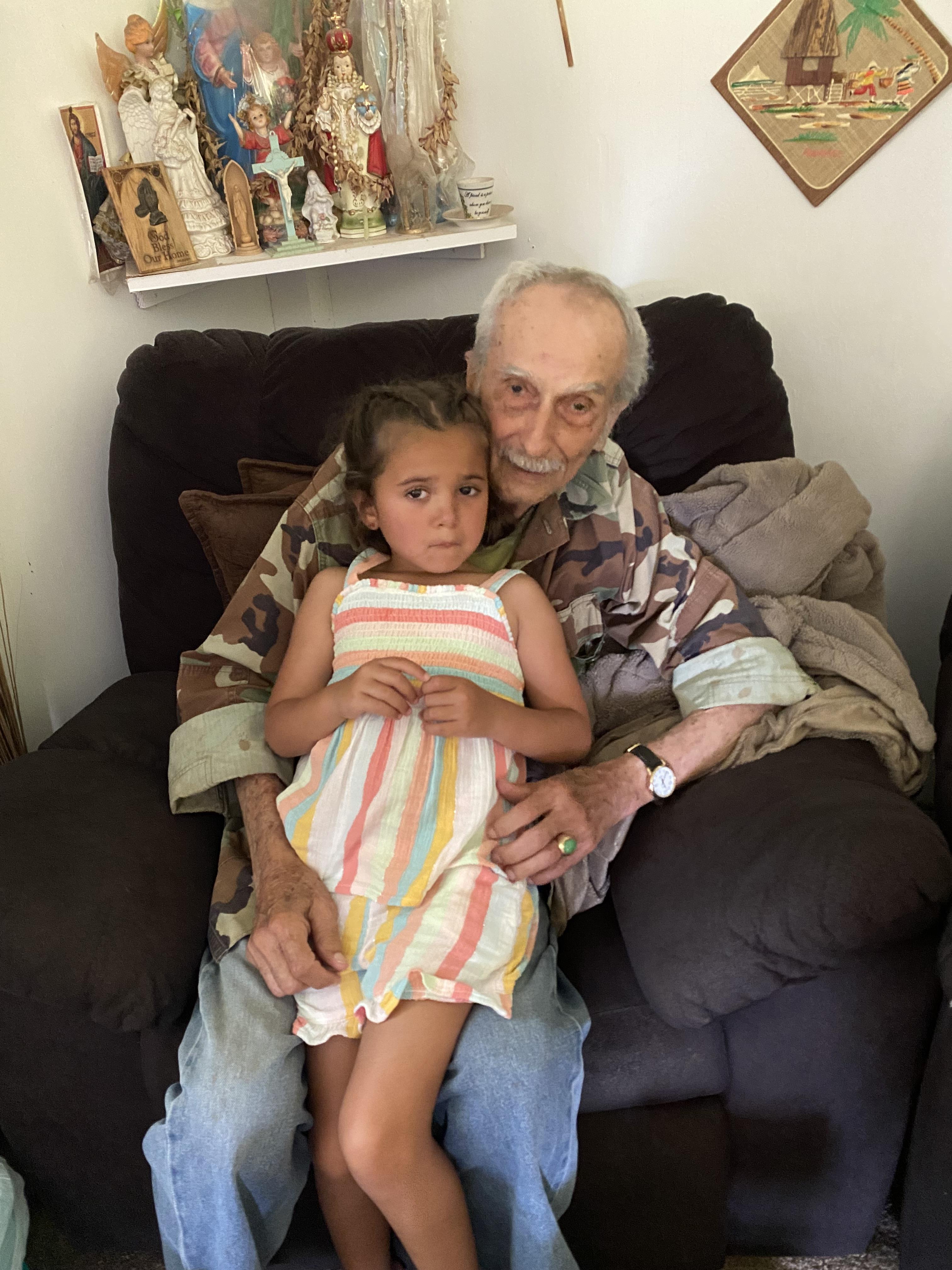 An old man and a young girl sitting on a couch