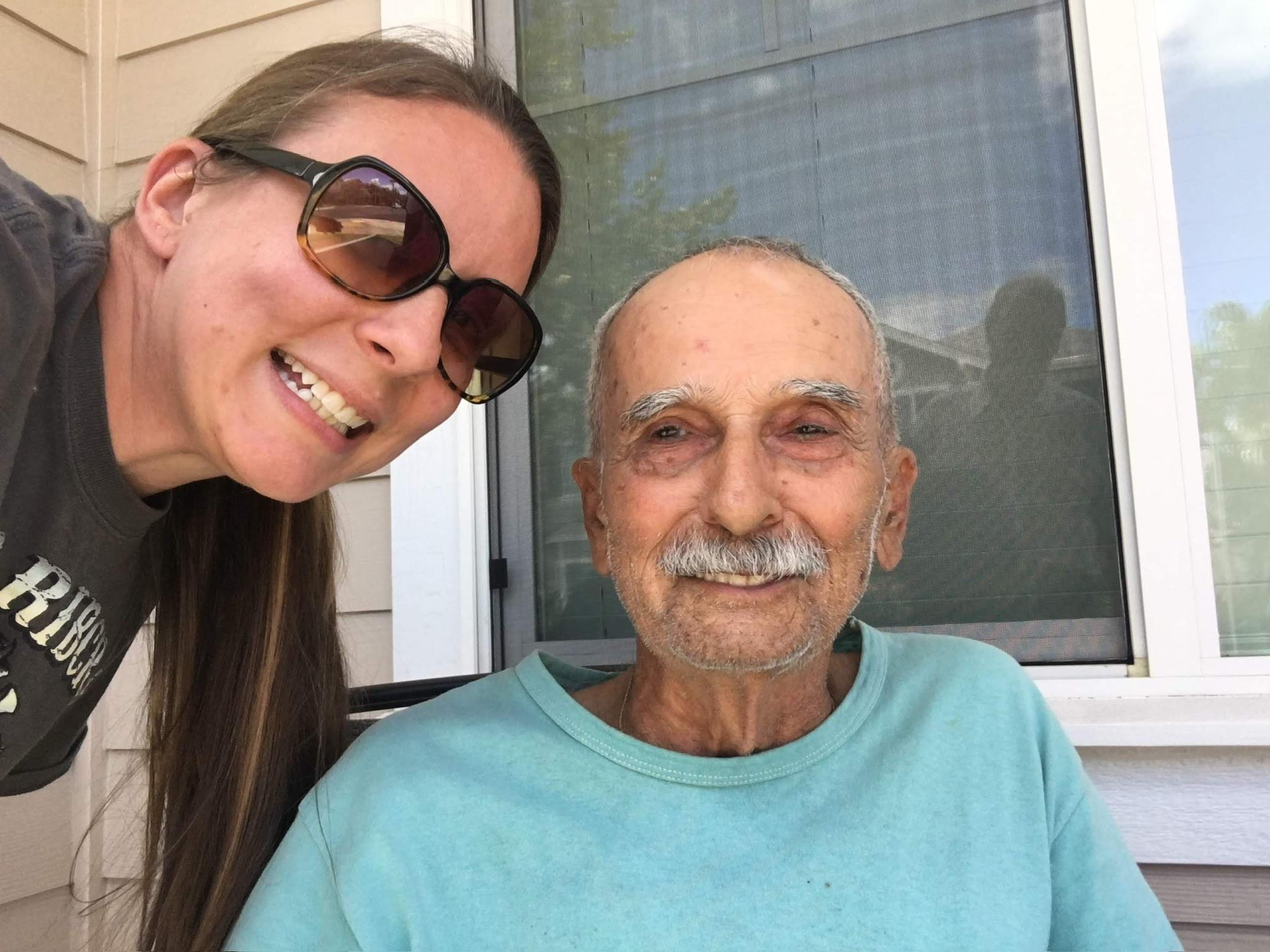 A woman smiling next to an old man