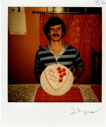 A man sitting in front of a cake