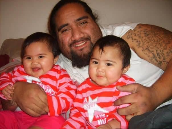 A man holding two babies