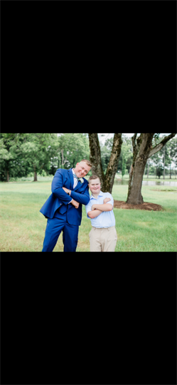 A man in a blue suit and tie standing next to a boy in a blue suit