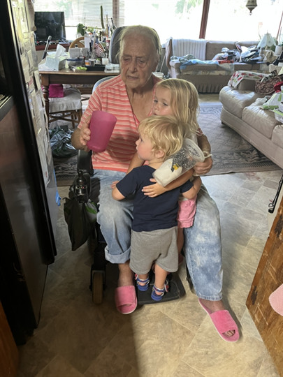 A woman holding a child and a cup