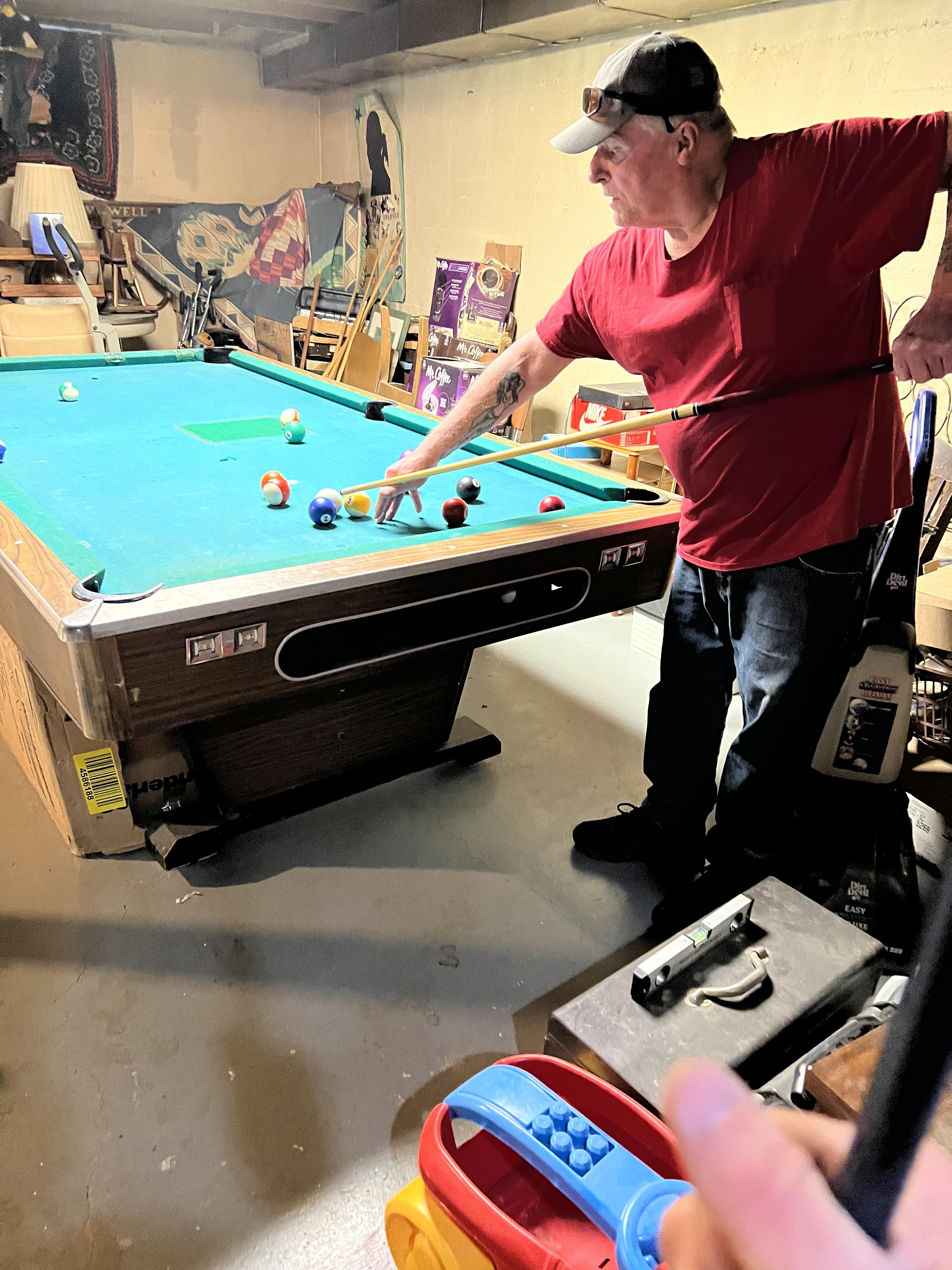 A man playing pool in a room